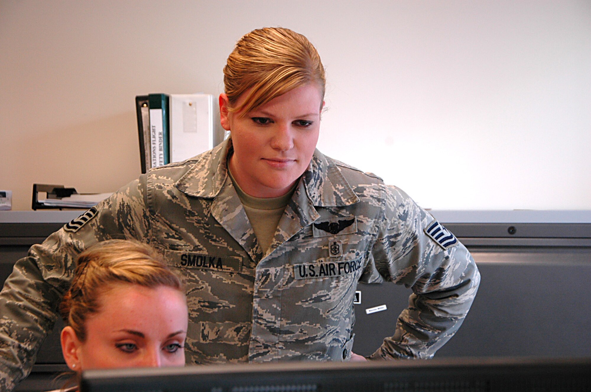 Tech. Sgt. Melissa Smolka, 446th Aeromedical Evacuation Squadron training manager, checks on a trainee's progress.  Smolka has created new, cost efficient training plans for Reservists in the squadron. (U.S. Air Force Reserve photo by Sandra Pishner)