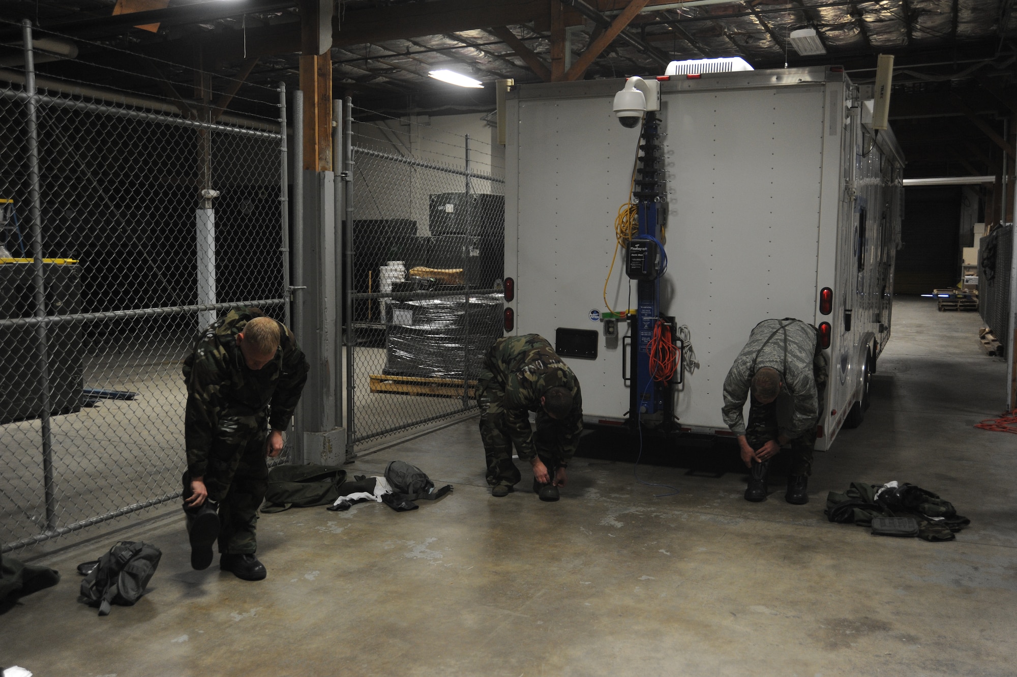 Airmen put on their mission oriented protective posture boots at Fairchild Air Force Base, Wash., April 10, 2014.  The boots are a factor in the drill held as part of the weekly Chemical, Biological, Radiological, and Nuclear operations class held at the base.  (U.S. Air Force photo by Airman 1st Class Sam Fogleman/Released)