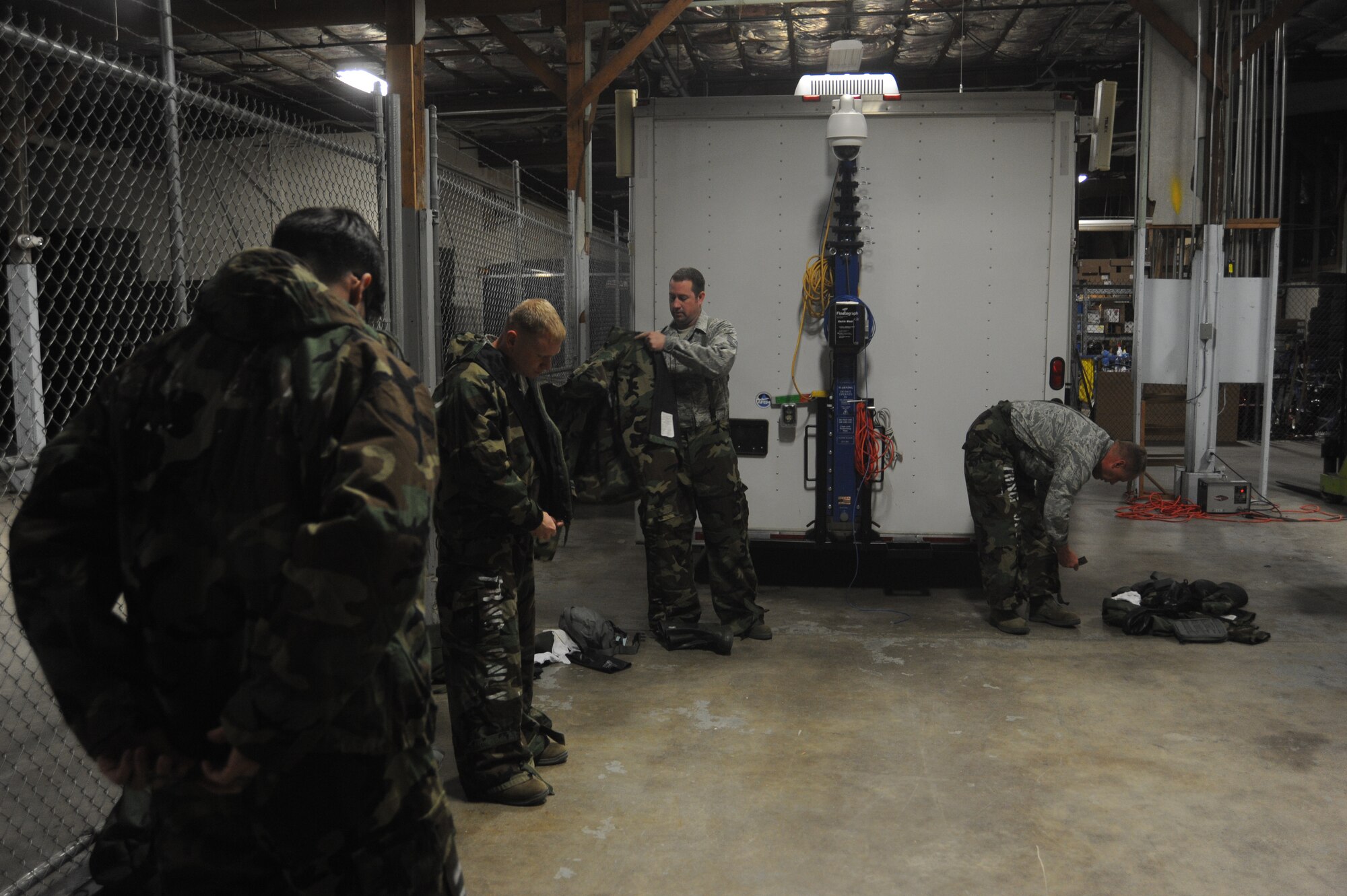 Members of Team Fairchild get into mission oriented protective posture gear at Fairchild Air Force Base, Wash., April 10, 2014.  The gear wearing is part of the weekly Chemical, Biological, Radiological and Nuclear operations training given at the base.  (U.S. Air Force by Airman 1st Class Sam Fogleman/Released)