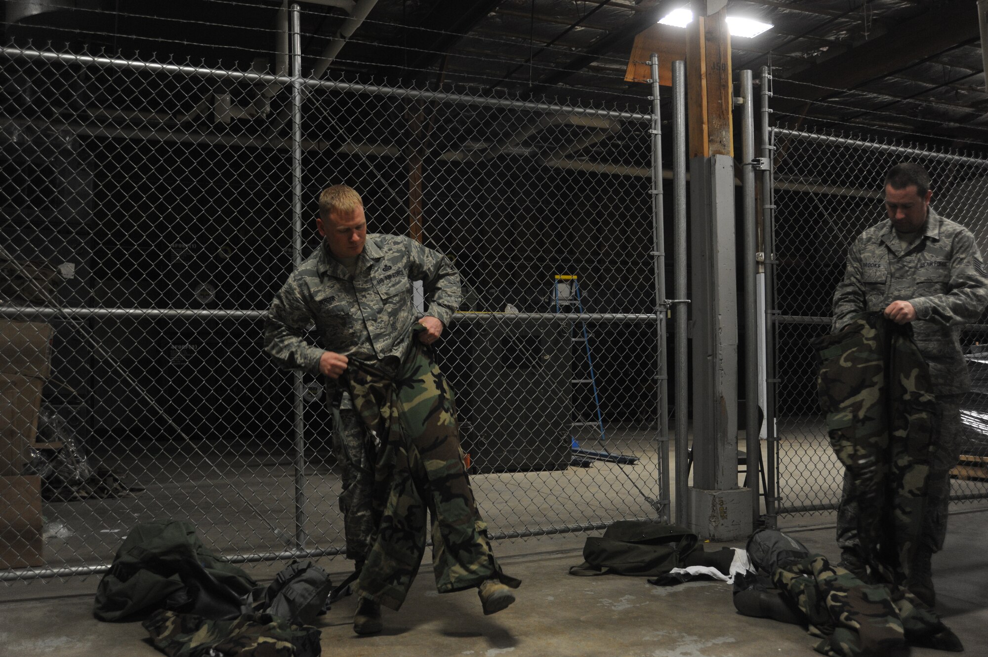 Airmen get into mission oriented protective posture gear at Fairchild Air Force Base, Wash., April 10, 2014.  The timed drill is part of the weekly Chemical, Biological, Radiological and Nuclear operations training given at the base.  (U.S. Air Force photo by Airman 1st Class Sam Fogleman/Released)