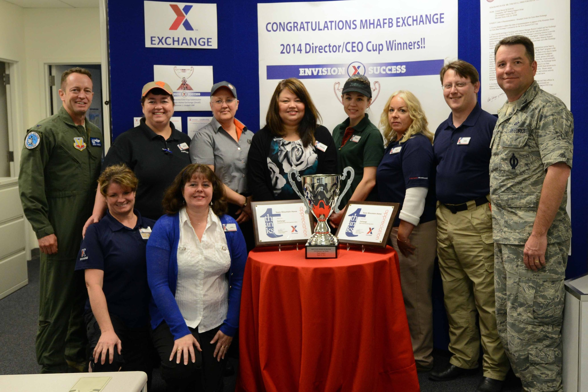 Base leadership and members of the Mountain Home Air Force Base Exchange pose for a group photo with the 2014 Director/CEO Cup  April 11, 2014, at Mountain Home AFB, Idaho. The Mountain Home AFB Exchange took home the trophy for the small category at the organization’s worldwide Main Store Manager/General Manager conference in Dallas, Texas, March 24, 2014. (U.S. Air Force photo by Senior Airman Caitlin Guinazu/RELEASED) 