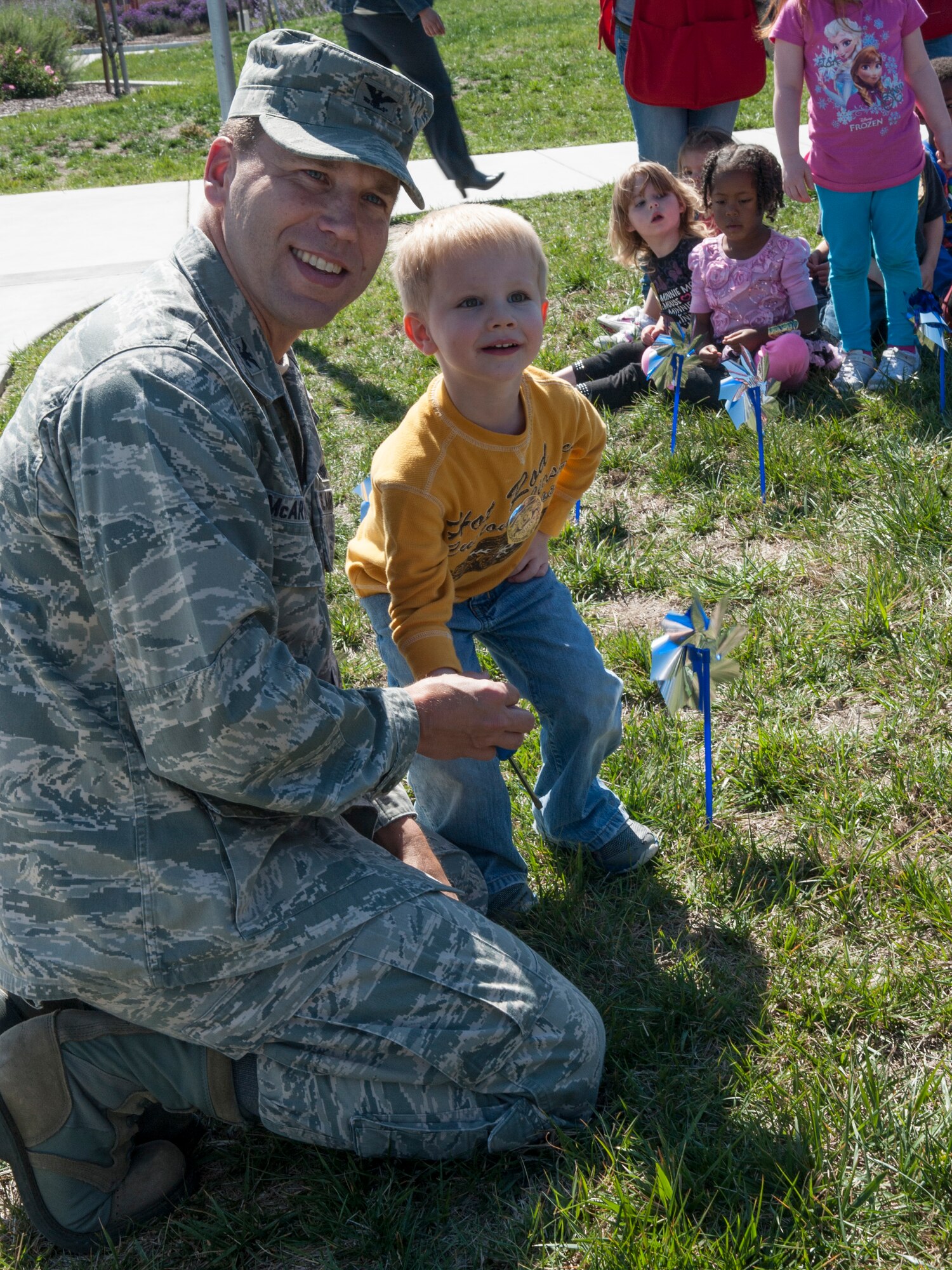 Col. Brent McArther, 30th Space Wing vice wing commander, and Steven, son of Maj. April Wimmer, 533rd Training Squadron director of operations, place a pinwheel in front of the Child Development Center, April, 7 2014, Vandenberg Air Force Base, Calif. The pinwheels are used as an awareness tool for Child Abuse Prevention Month. (U.S. Air Force photo/Airmen 1st Class Yvonne Morales)