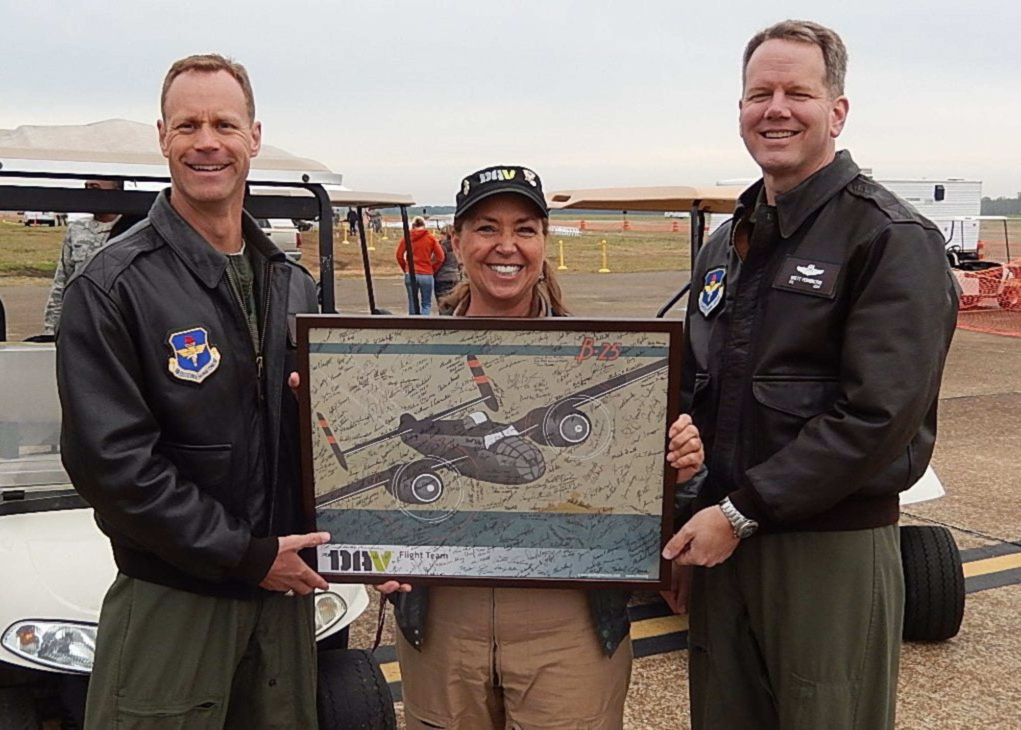 Lynn May, DAV Flight Team event and media coordinator, holds up the poster of the DAV signed by veterans who attended the Air Show, with Col. Jim Sears, 14th Flying Training Wing Commander, and Col. Brett Pennington, 14th Operations Group Commander. The Columbus Air Force Base Air Show was just one stop for the Disabled American Veterans on a nationwide tour that aims to increase public awareness of disabled veterans and provide information on DAV programs and benefits. (Courtesy Photo)