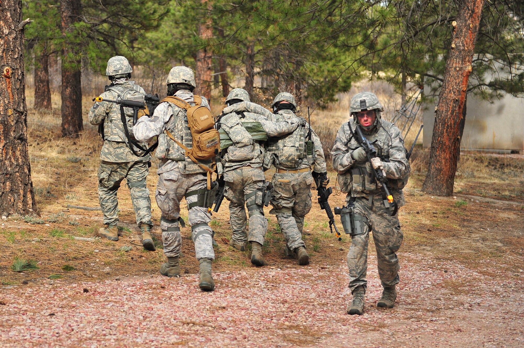 Air Force Reservists carry off simulated wounded to a neutral area while Senior Airman Hunter Weiss provides rear cover during a compound raid April 9, 2014, at the U.S. Air Force Academy in Colorado Springs, Colo. The 710th and 310th Security Forces Squadrons held a six-day combat leaders course while living in field conditions. Each day’s mission is designed around the main objective of the day’s classroom instruction, placing practical application of combat maneuvers into complex mission environments. The 710th SFS is out of Buckley Air Force Base, Colo., and the 310th SFS is out of Schriever AFB. (U.S. Air Force photo/Tech. Sgt. Nicholas B. Ontiveros)