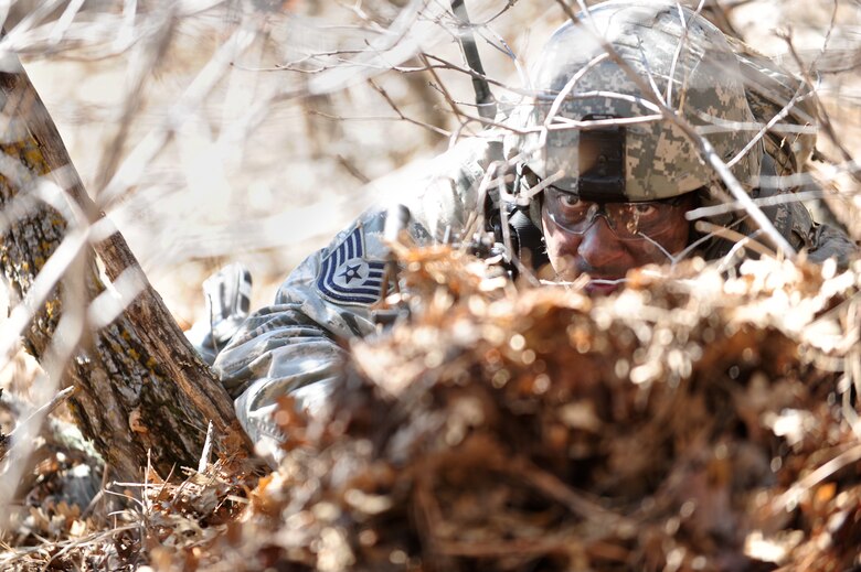 Camouflaged and positioned, Air Force Reserve Tech. Sgt. Kelly Carney focuses on an anticipated enemy ambush April 10, 2014, at the U.S. Air Force Academy in Colorado Springs, Colo. The 710th and 310th Security Forces Squadrons held a six-day combat leaders course while living in field conditions. Each day’s mission is designed around the main objective of the day’s classroom instruction, placing practical application of combat maneuvers into complex mission environments. The 710th SFS is out of Buckley Air Force Base, Colo., and the 310th SFS is out of Schriever AFB. (U.S. Air Force photo/Tech. Sgt. Nicholas B. Ontiveros)