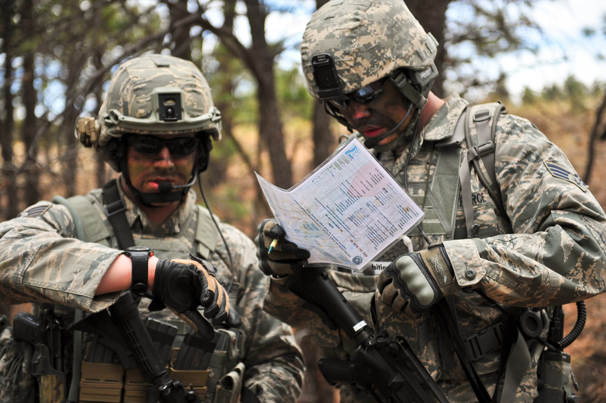 Air Force Staff Sgt. Andrew Miller (left) and AF Reserve Senior Airman Grant Nelson, security forces members, thoroughly check their time and position on a map during a training mission April 9, 2014, at the U.S. Air Force Academy in Colorado Springs, Colo. The 710th and 310th Security Forces Squadrons held a six-day combat leaders course while living in field conditions. Each day’s mission is designed around the main objective of the day’s classroom instruction, placing practical application of combat maneuvers into complex mission environments. The 710th SFS is out of Buckley Air Force Base, Colo., and the 310th are out of Schriever AFB. The 710th SFS is out of Buckley Air Force Base, Colo., and the 310th is out of Schriever AFB. (U.S. Air Force photo/Tech. Sgt. Nicholas B. Ontiveros)
