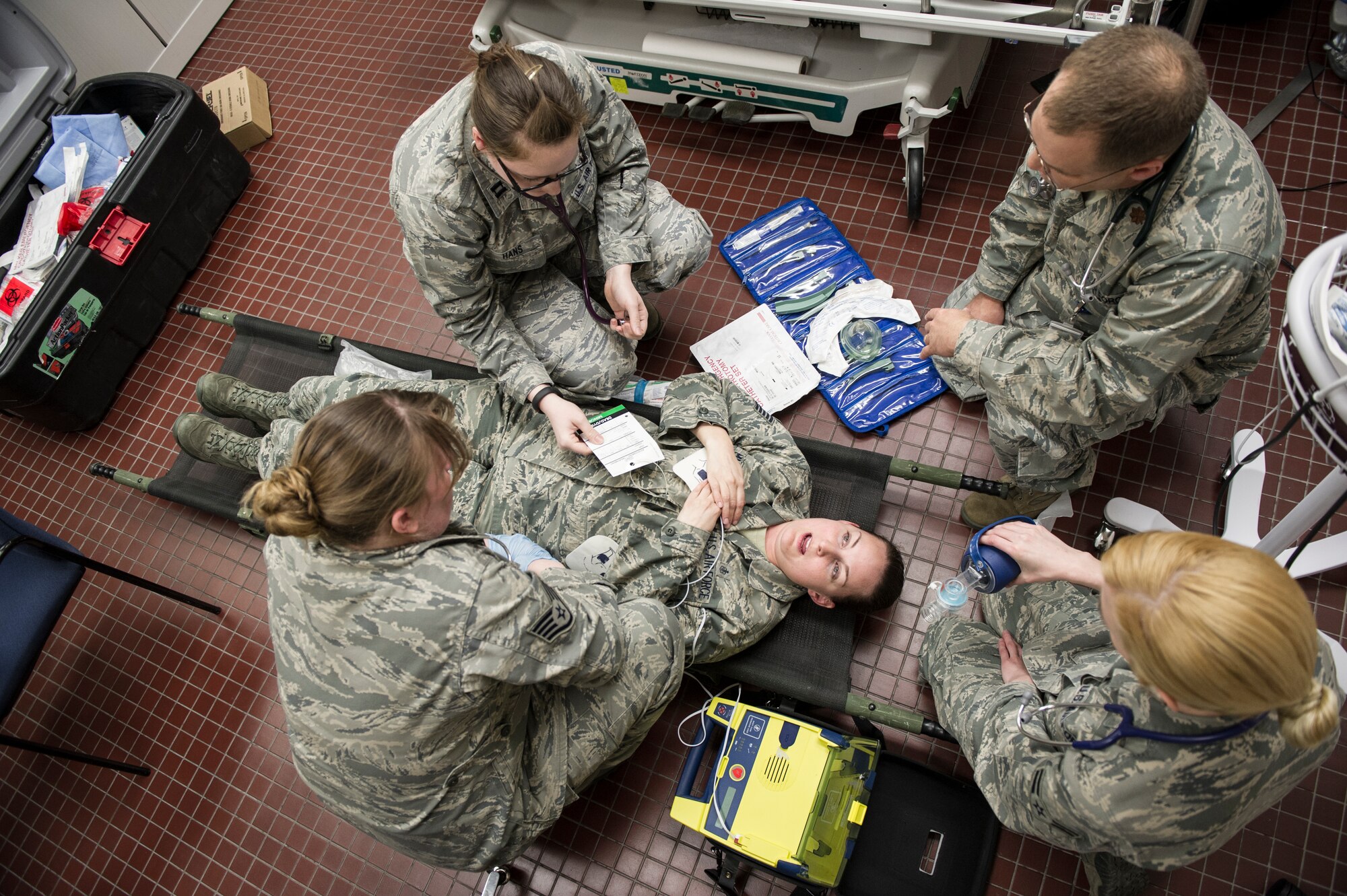 Medical technicians assess a simulated victim during a casulty exercise April 1, 2014, Eielson Air Force Base, Alaska. Injuries included lacerations, whiplash, head injuries, fractures, sprains, panic and traumatic stress. (U.S. Air Force photo by Senior Airman Joshua Turner/Released)