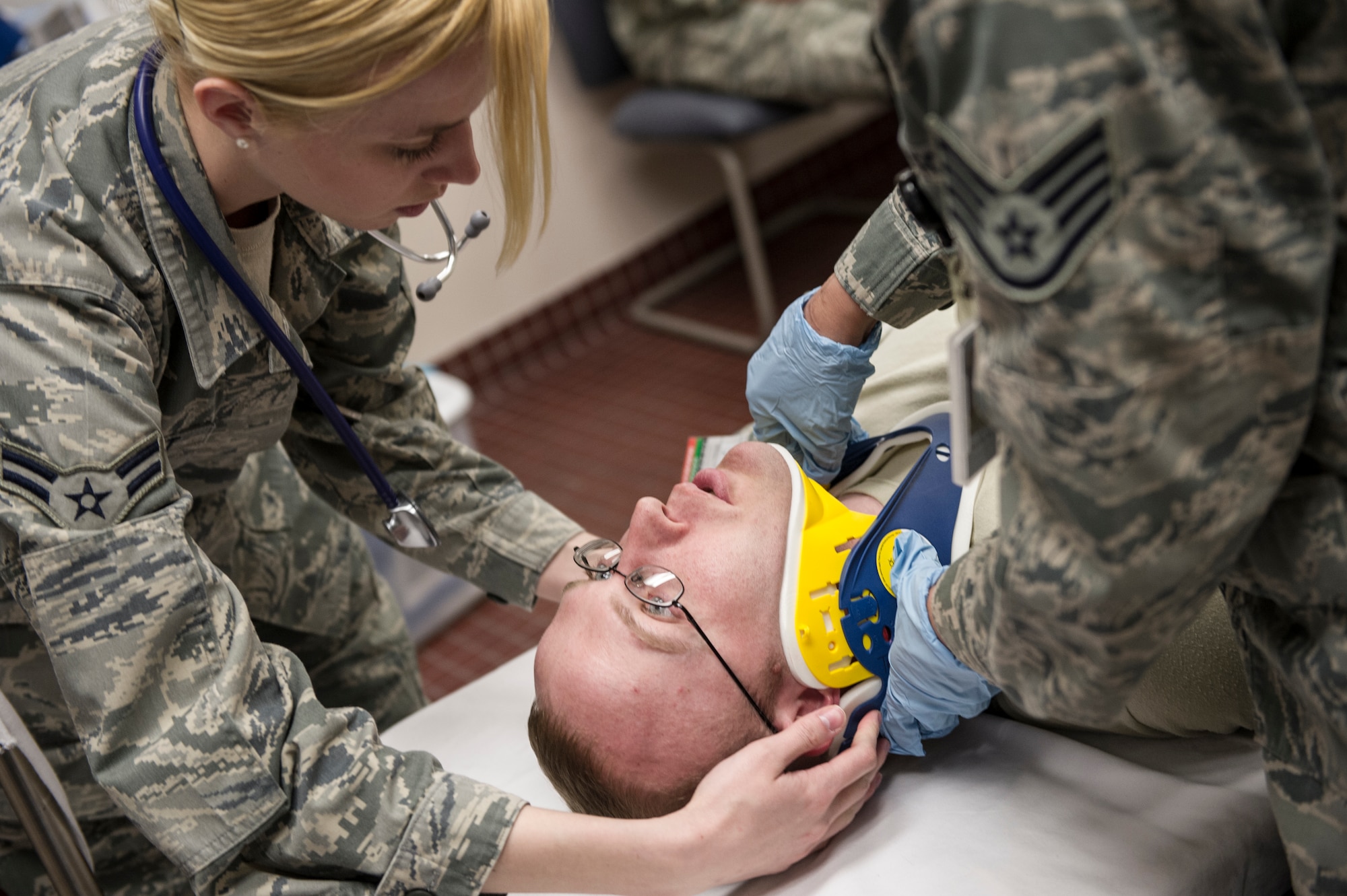 Staff Sgt Krystal Champ and Airman 1st Class Kaylam Padgett, 354th Medical Operations Squadron medical technicians, stabilize the neck of a simulated victim during a casulty exercise April 1, 2014, Eielson Air Force Base, Alaska. Injuries included lacerations, whiplash, head injuries, fractures, sprains, panic and traumatic stress. (U.S. Air Force photo by Senior Airman Joshua Turner/Released)