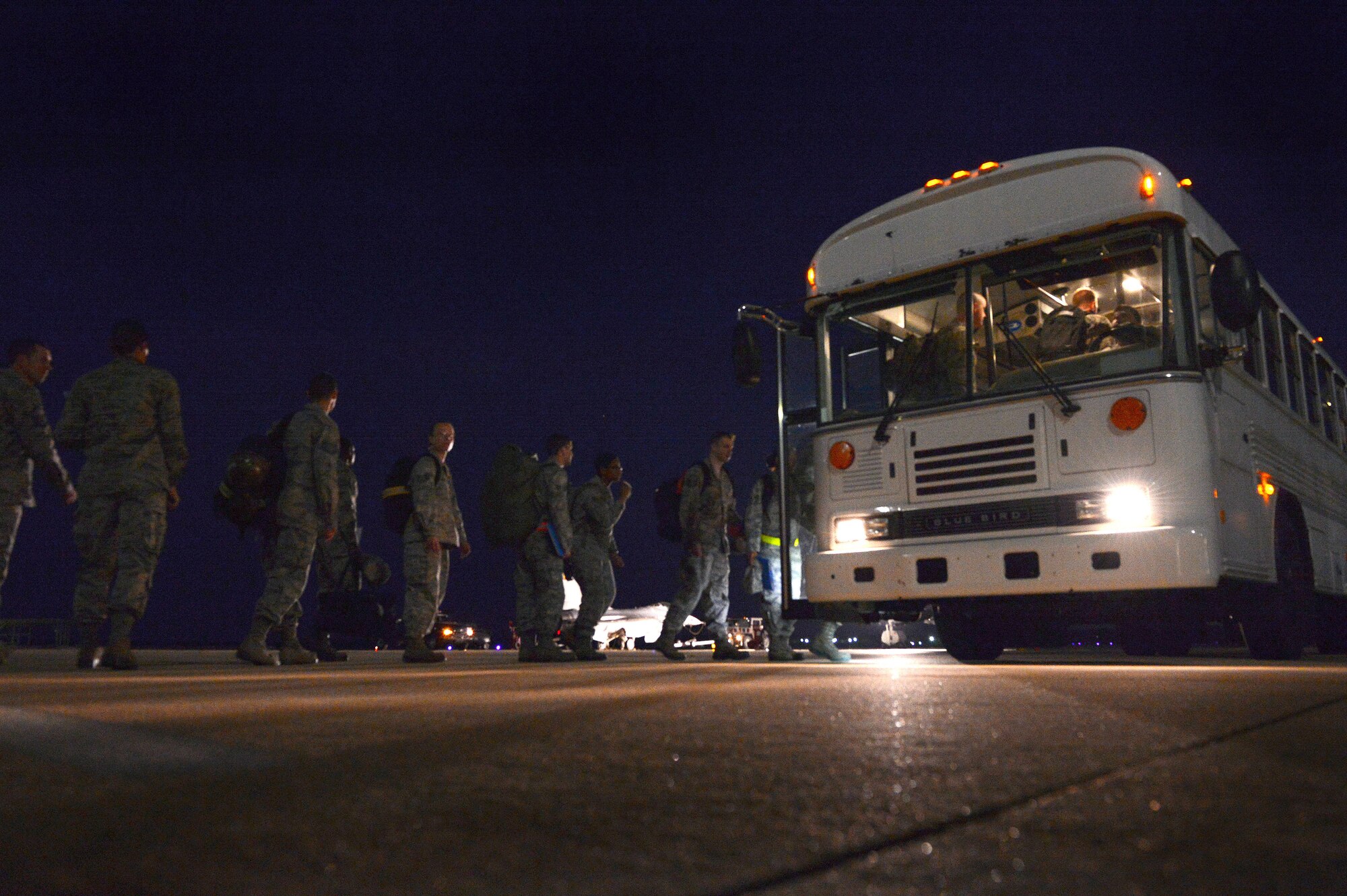 U.S. Air Force Airmen line up to board a bus during Phase I of an operational readiness exercise at Shaw Air Force Base, S.C., April 10, 2014. Phase I consisted of a simulated deployment where each Airman and their gear was processed through the deployment processing center before simulating boarding of an aircraft. (U.S. Air Force photo by Airman 1st Class Jensen Stidham/Released)