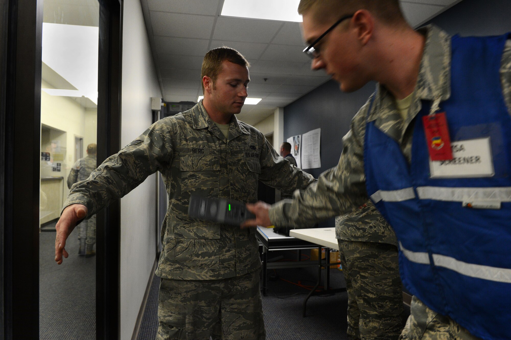 U.S. Air Force Airman Troy Dunn, 20th Logistics Readiness Squadron vehicle maintenance journeyman, performs a security scan on a deploying Airman during Phase I of an operational readiness exercise at Shaw Air Force Base, S.C., April 10, 2014. Airmen simulated preparing for a deployment by processing through the deployment processing center and a Transportation Security Administration screening before departing. (U.S. Air Force photo by Airman 1st Class Jensen Stidham/Released)