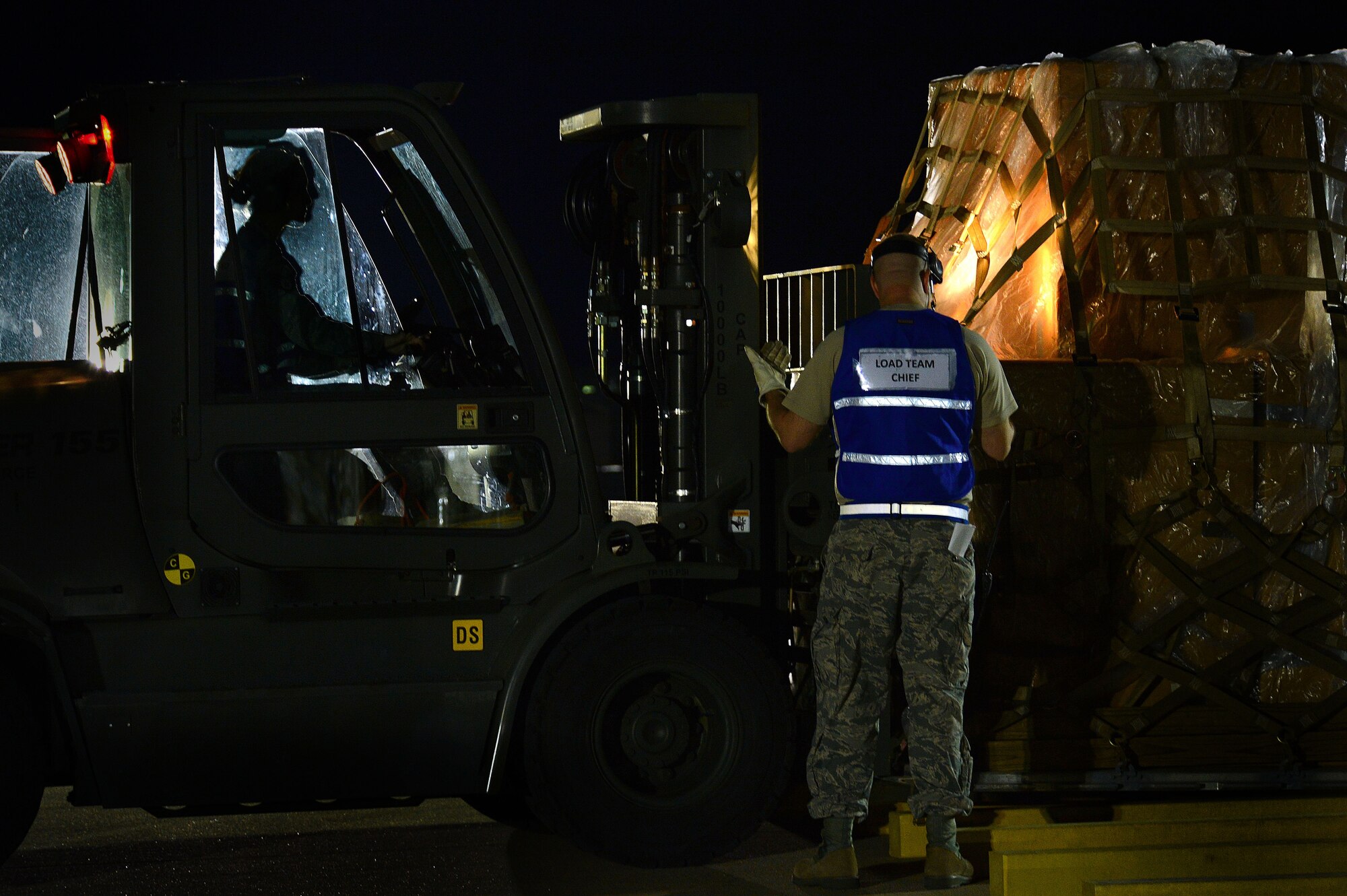 U.S. Air Force Tech. Sgt. Christopher Miley, 20th Logistic Readiness Squadron assistant first sergeant, directs Staff Sgt. Ashley Depuy, 20th LRS vehicle operations control center dispatcher, while she transports cargo at Shaw Air Force Base, S.C., April 10, 2014. The 20th LRS, one of several squadrons that participated in Phase I of an operational readiness exercise, moved palletized cargo on to a simulated cargo plane. (U.S. Air Force photo by Airman 1st Class Jensen Stidham/Released)