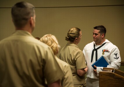 Petty Officer 3rd Class Travis Kirckof is congratulated by his shipmates after receiving the Navy and Marine Corps Medal April 11, 2014, at Joint Base Charleston – Weapons Station, S.C. Kirckof received the medal for his heroic actions while serving as a Search and Rescue Swimmer on USS Guardian (MCM 5), where he helped 46 of his shipmates to safety after the Guardian ran aground on a reef in the Sulu Sea, Jan. 17, 2013. (U.S. Air Force photo/Senior Airman Dennis Sloan)