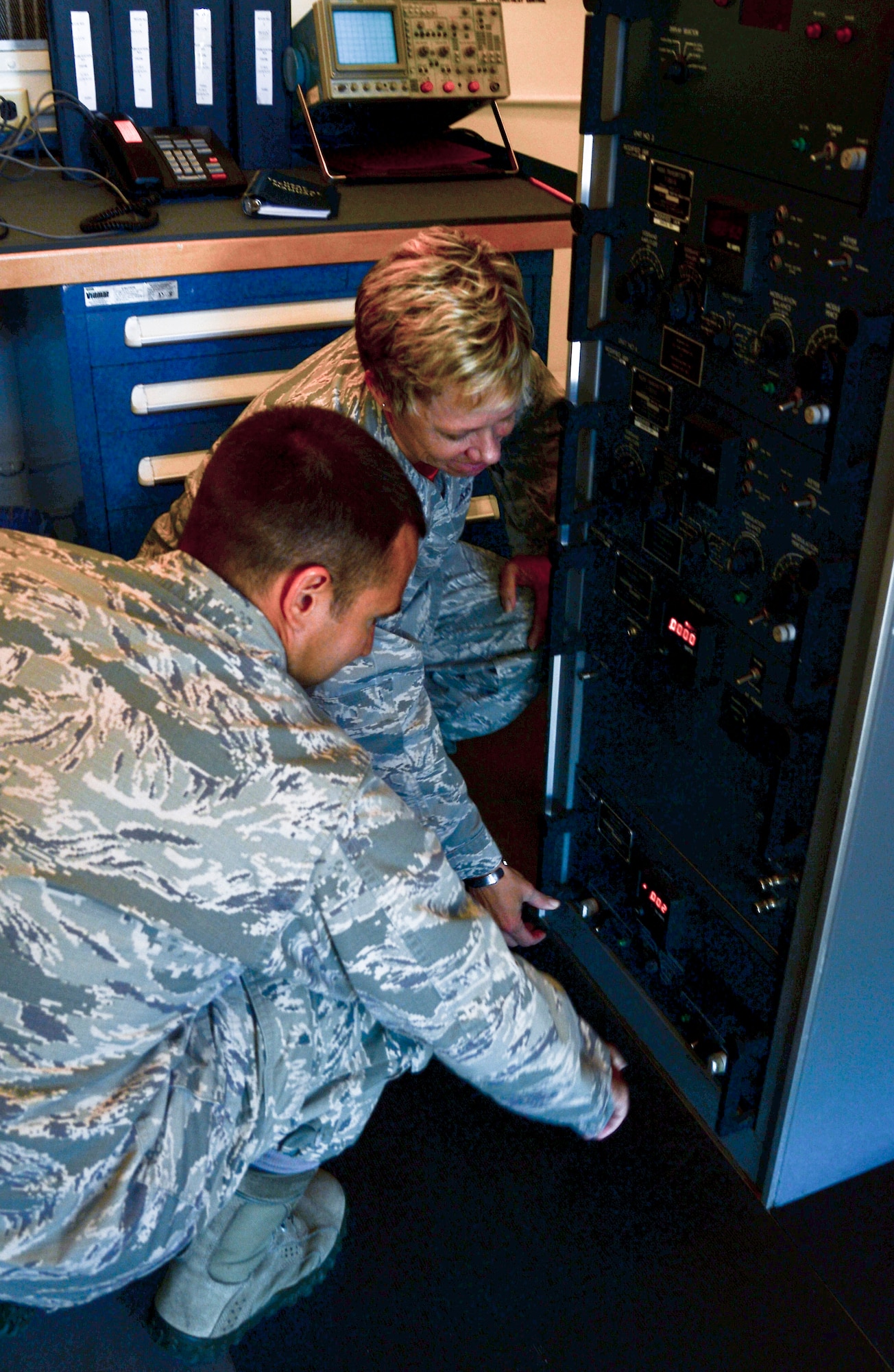 Lt. Col. Marlyce Roth, 6th Communications Squadron commander, and Capt. Christopher Wiley, 6th CS operations flight commander, turns off the power to the old instrumental landing systems equipment, April 11, 2014 at MacDill Air Force Base, Fla. The modernization is scheduled to be completed by May 22, 2014, where the commander of the 6th OSS will turn on the new ILS equipment. (U.S. Air Force photo by Senior Airman Jenay Randolph/Released)