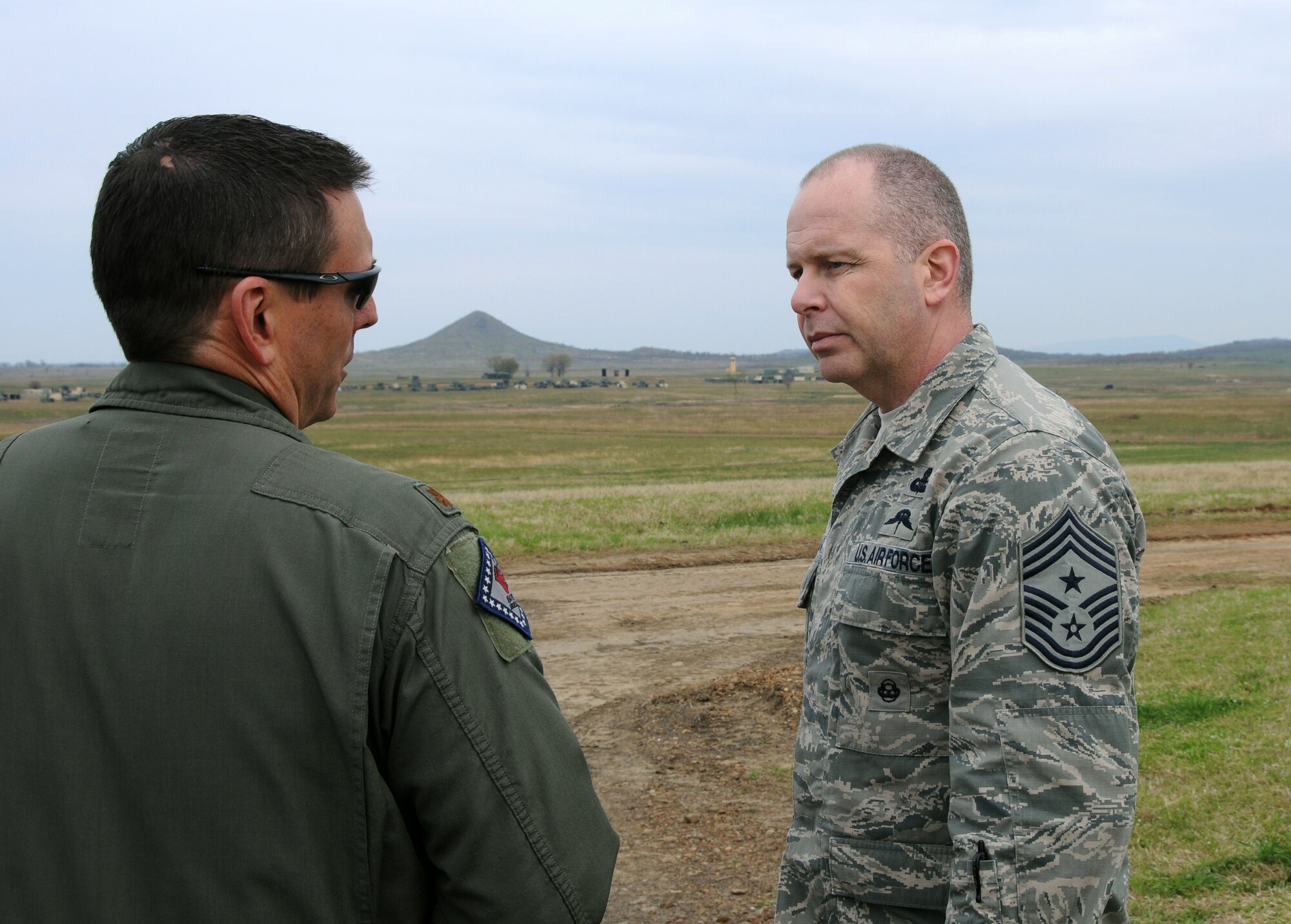 Air National Guard Command Chief Master Sgt. James W. Hotaling speaks with Maj. Doug Davis, 188th Fighter Wing Detachment 1 Razorback Range commander, during his visit to the 188th Fighter Wing April 5, 2014. Hotaling spoke with enlisted Airmen across the base about professionalism, resilience and recognition, and observed close air support training at the range. (U.S. Air National Guard photo by Senior Airman John Hillier/released)