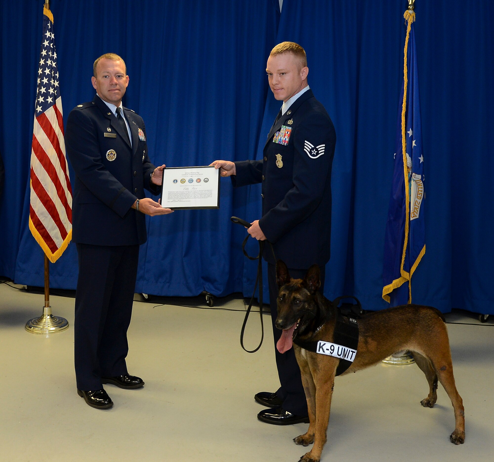 Lt. Col. Nathan Schalles, 6th Security Forces Squadron commander, Staff Sgt. Shannon Hutto, 6th SFS military working dog trainer, and MWD Eddie pose for a photo during Eddie’s retirement ceremony at MacDill Air Force Base, Fla., April 11, 2014. MWD Eddie retired with full ceremonial honors. (U.S. Air Force photo by Senior Airman Shandresha Mitchell/ Released)