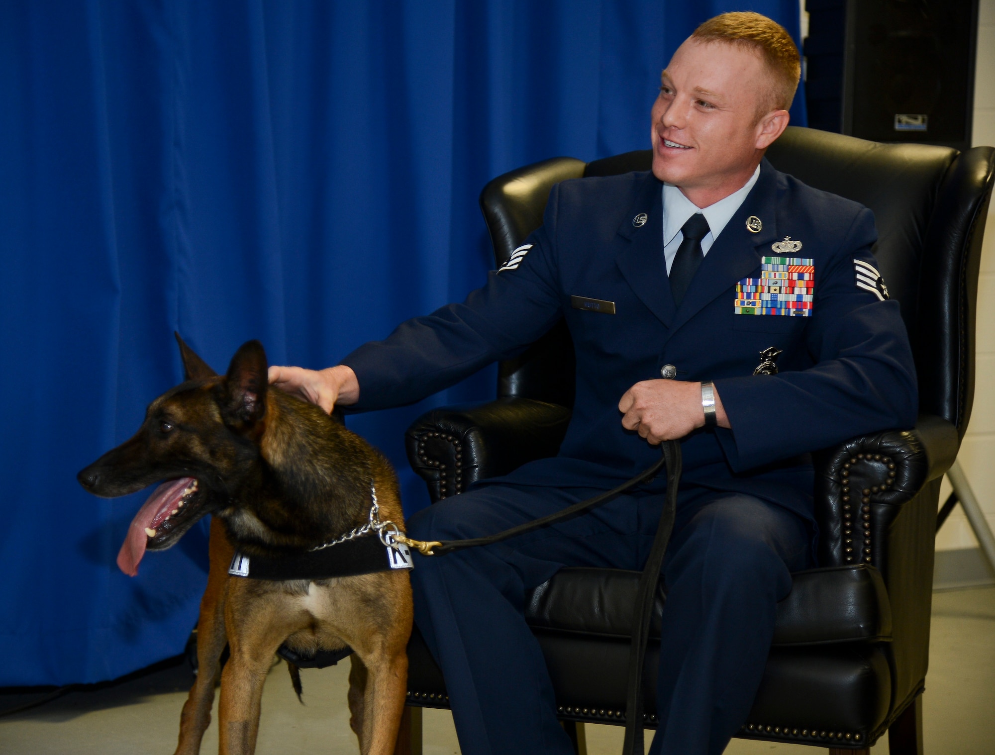 Staff Sgt. Shannon Hutto, 6th Security Forces Squadron military working dog trainer, pets MWD Eddie during Eddie’s retirement ceremony at MacDill Air Force Base, Fla., April 11, 2014. With more than five years of service at MacDill, Eddie has deployed once and conducted 15 secret service missions. (U.S. Air Force photo by Senior Airman Shandresha Mitchell/ Released)