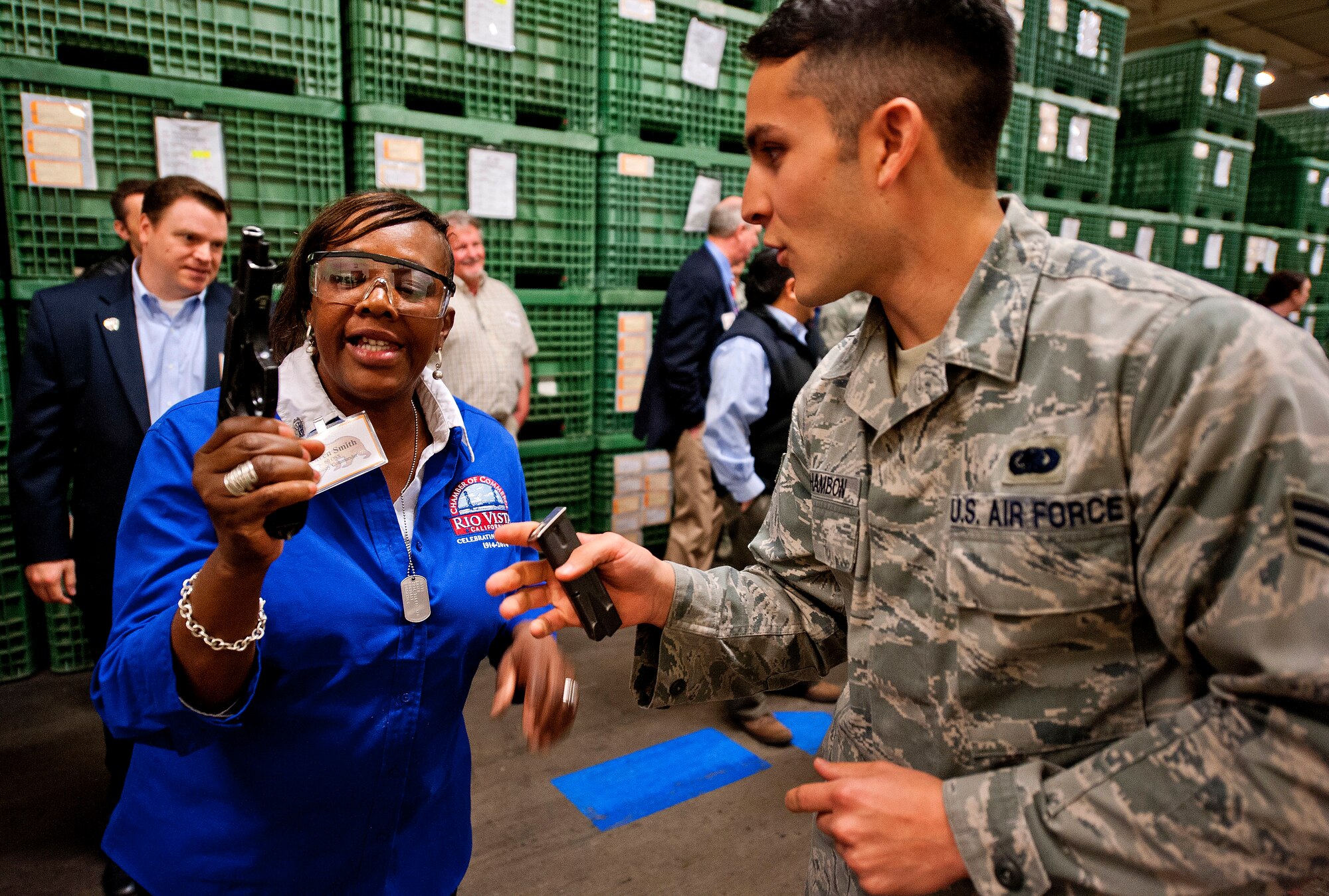Senior Airman Christian Schambon, a weapons handler for the 60th Logistics Readiness Squadron, answers questions for  Karen Smith, 60th Operations Support Squadron Honorary Commander about the M-9 rifle during a mock deployment line at the deployment readiness center as part of the Honorary Commander Boot Camp, April 3.