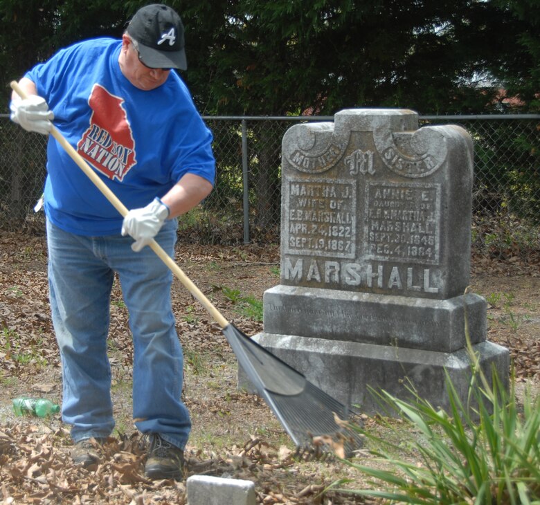 Joseph Bossi, 78th Civil Engineer Group environmental specialist, cleans up one of the grave sites at Bryant Cemetery.(U.S. Air Force photo by Misuzu Allen)