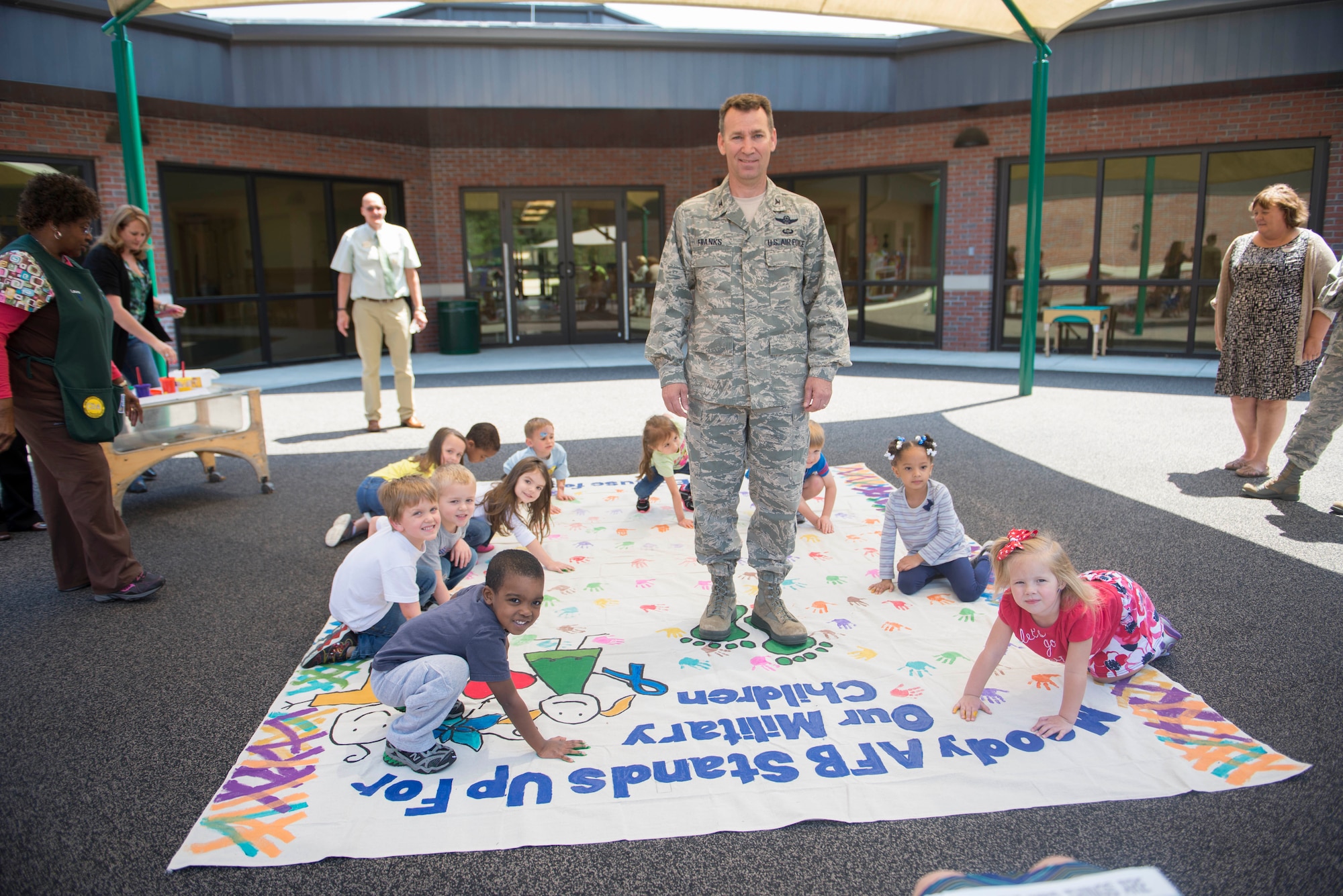 U.S. Air Force Col. Chad Franks, 23d Wing commander, helps paint a child abuse awareness poster with Child Development Center children of military service members April 9, 2014, at Moody Air Force Base, Ga. The poster was donated by the 23d Civil Engineer Squadron.
(U.S. Air Force photo by Airman Dillian Bamman/Released)
