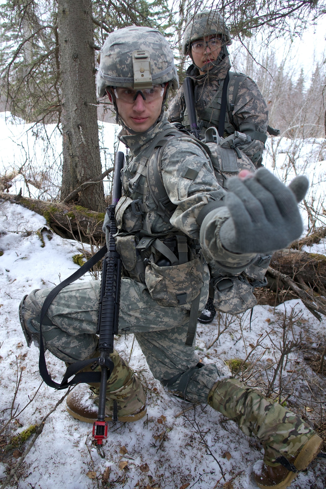 JOINT BASE ELMENDORF-RICHARDSON, Alaska -- Laramie Yancey, a junior-standing Army ROTC cadet from the University of Alaska Fairbanks, calls one his team leaders forward while setting a simulated ambush April 4 during the University of Alaska Anchorage and UAF Joint Field Training Exercise at JBER's Camp Mad Bull. Army ROTC cadets learn how to operate in a counterinsurgency environment. (U.S. Air Force photo/David Bedard)