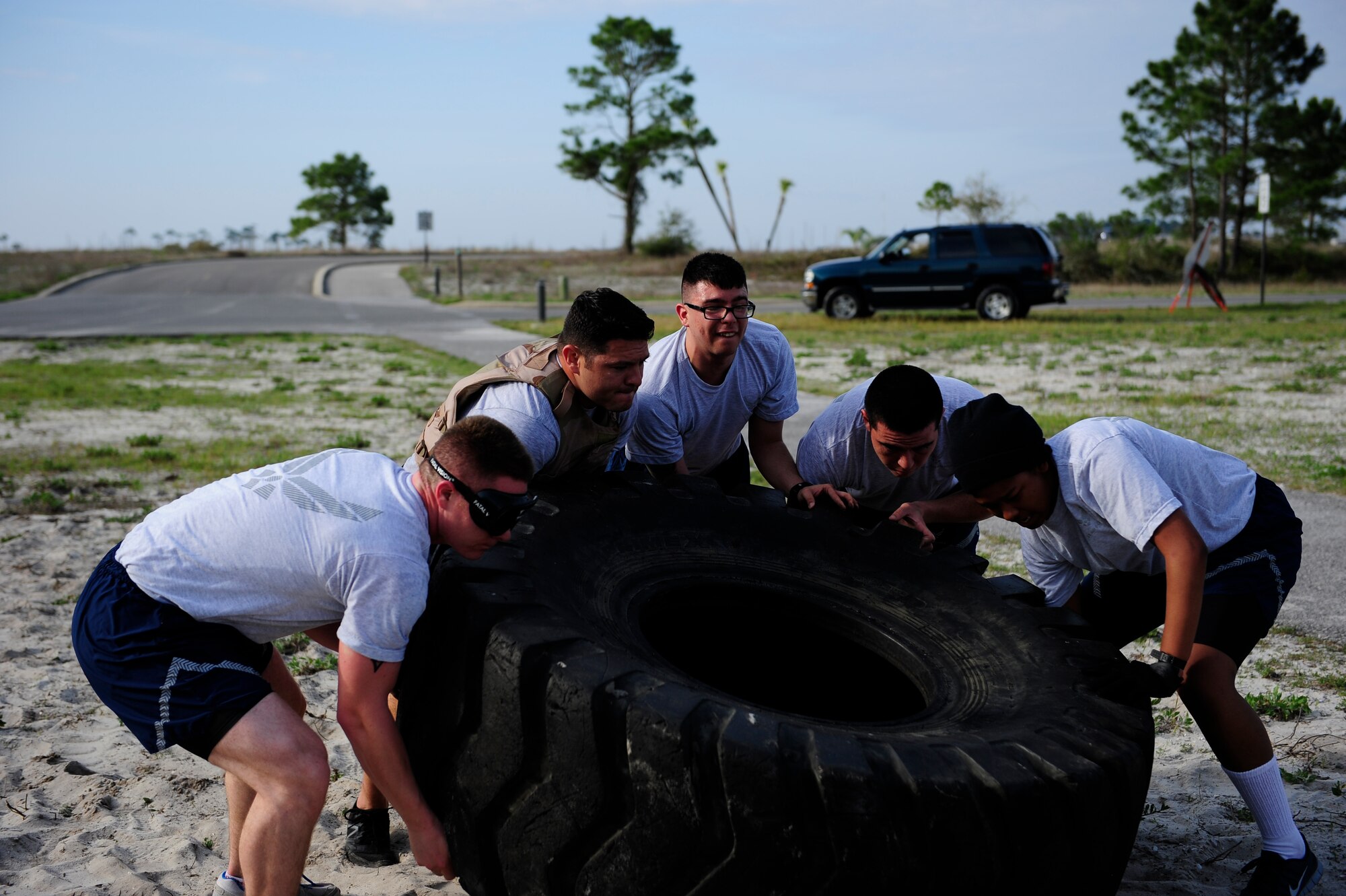 Airmen flip a tire during the CLEAR Challenge Obstacle Course on Hurlburt Field, Fla., April 11, 2014. The obstacle course was designed to help build camaraderie between teammates while raising their awareness about sexual assault. (U.S. Air Force photo/Senior Airman Krystal m. Garrett)  