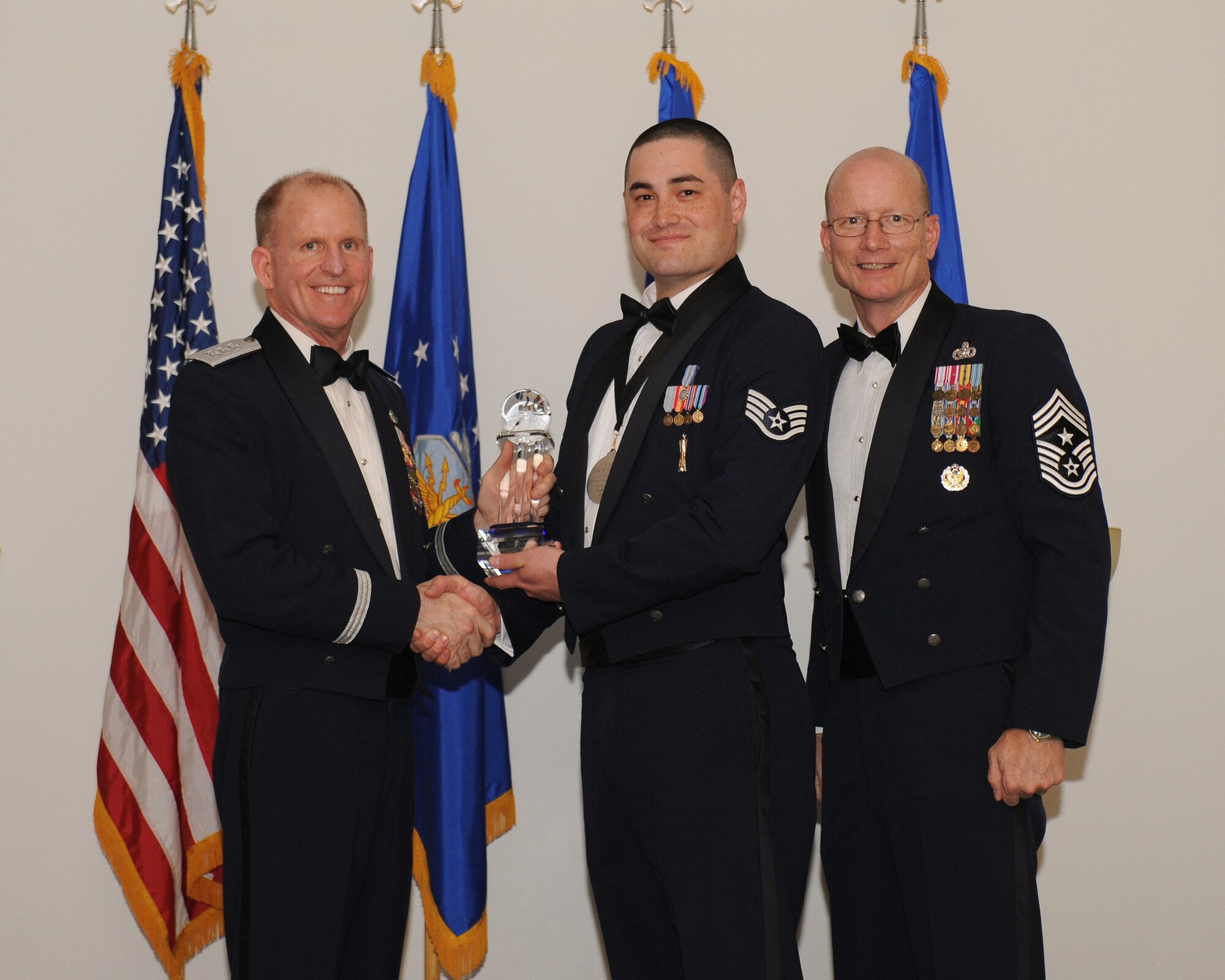 Lt. Gen. Stephen Wilson, commander, Air Force Global Strike Command, and Chief Master Sgt. Terry West, command chief AFGSC, present Staff Sgt. Erik Dempsey, 91st Maintenance Operations Squadron, Minot Air Force Base, N.D., with AFGSC Outstanding Airman of the Year honors, Honor Guard Member category, at Barksdale AFB, La., April 10. (U.S. Air Force photo by Senior Airman Benjamin Gonsier)