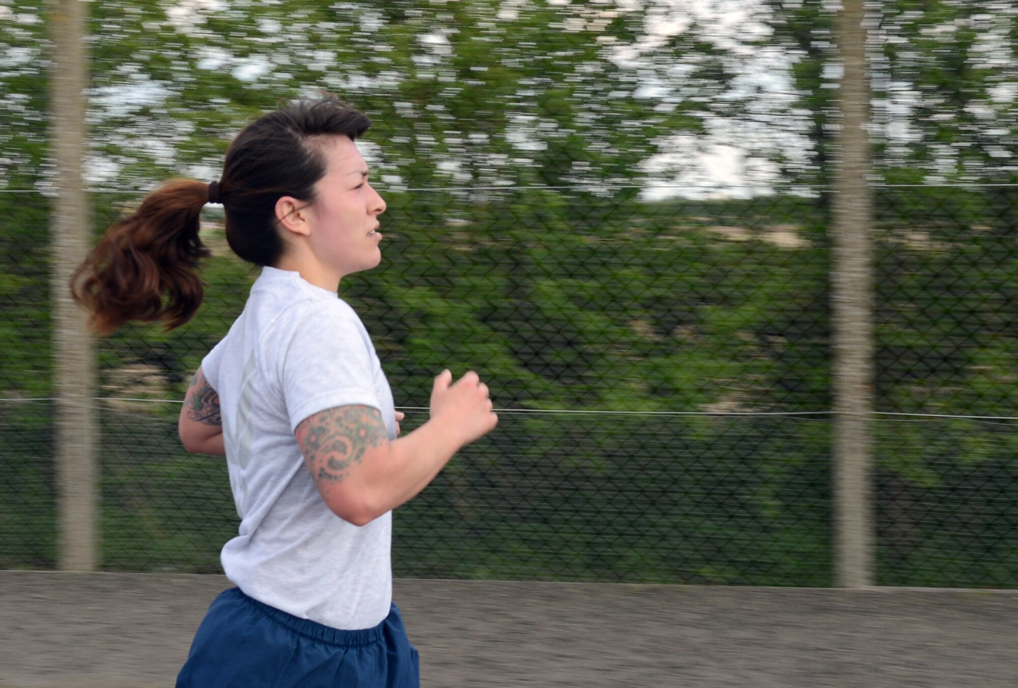 A Team Mildenhall Airman finishes the last leg of the 100th Air Refueling Wing 5 km run April 11, 2014, on RAF Mildenhall, England. Participants ran a designated route around the base perimeter. Every month, Team Mildenhall members gather for exercise and friendly competition. (U.S. Air Force photo by Airman 1st Class Jonathan Light/Released)