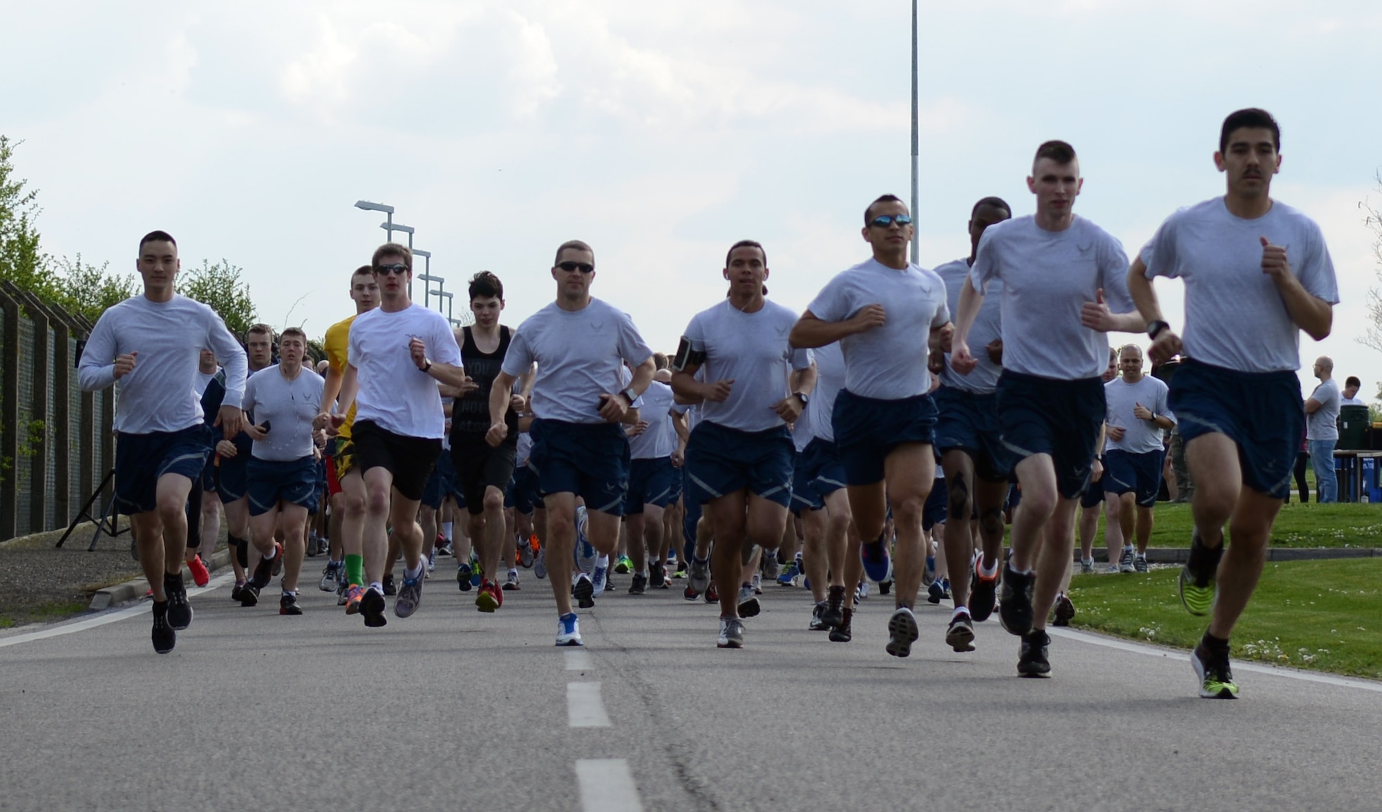 Team Mildenhall members kick off the 100th Air Refueling Wing 5 km run April 11, 2014, on RAF Mildenhall, England. Starting at the Hardstand Fitness Center, participants run along a designated base perimeter route. Every month, Team Mildenhall members gather for exercise and friendly competition. (U.S. Air Force photo by Airman 1st Class Jonathan Light/Released)