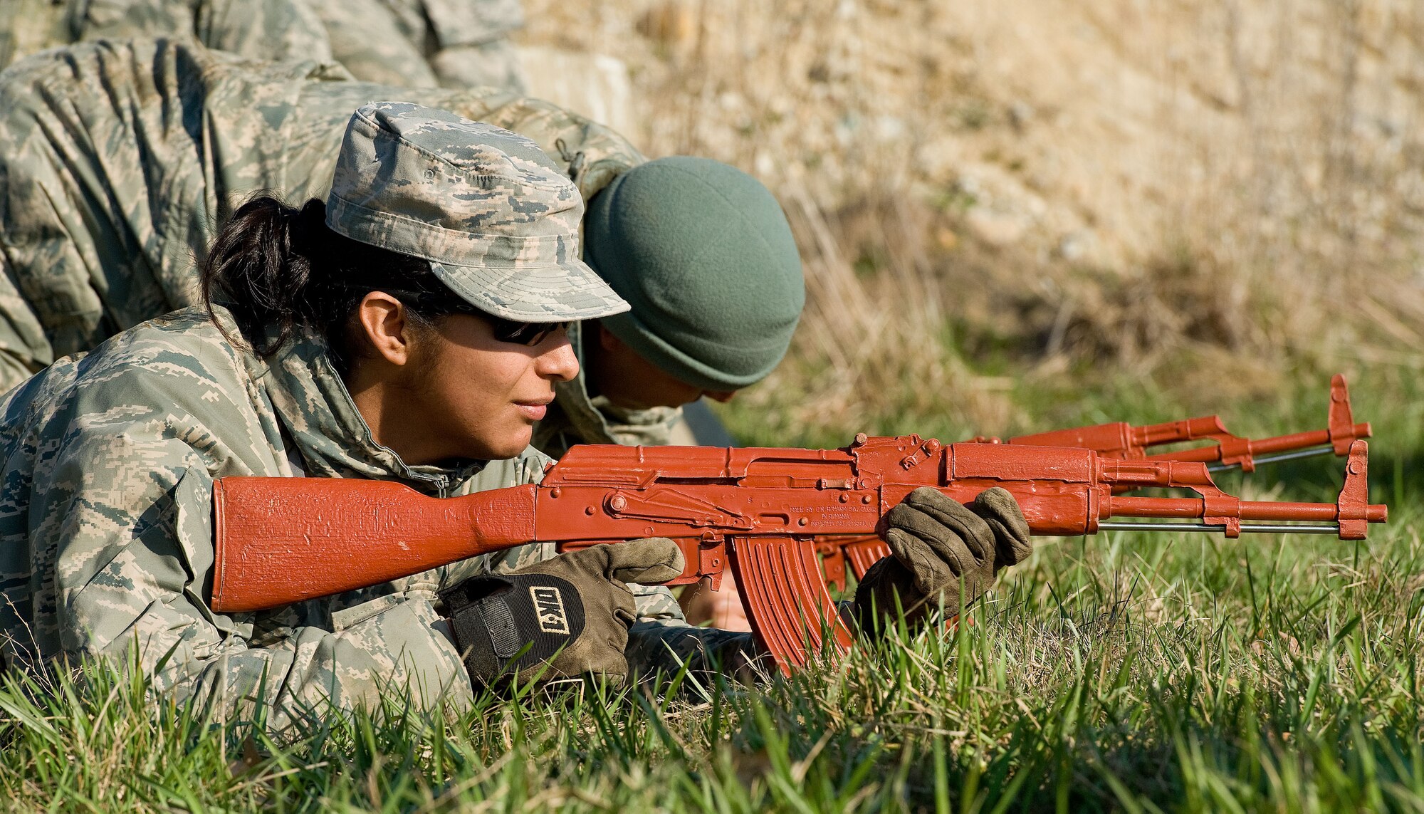 Senior Airman Laura Jauregui, , a 436th Civil Engineer Squadron structural journeyman, lays in the M16 prone firing position after crawling under simulated concertina wire April 9, 2014, at the deployment training area on Dover Air Force Base, Del. Jauregui went through three days of training honing her skills as a Prime Base Engineer Emergency Forces team member. (U.S. Air Force photo/Roland Balik)