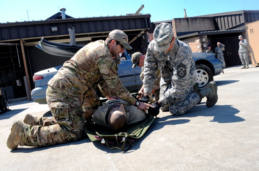 U.S. Air Force Tech. Sgt. Shane Brickey, 38th Rescue Squadron pararescueman, assists Chief Master Sgt. Scott Fuller, Ninth Air Force command chief, in securing a patient to a litter at Moody Air Force, Ga., April 9, 2014. After breaking into the vehicle, Fuller and members of the 38th RQS prepared for safe transport. (U.S. Air Force photo by Senior Airman Olivia Bumpers/Released)