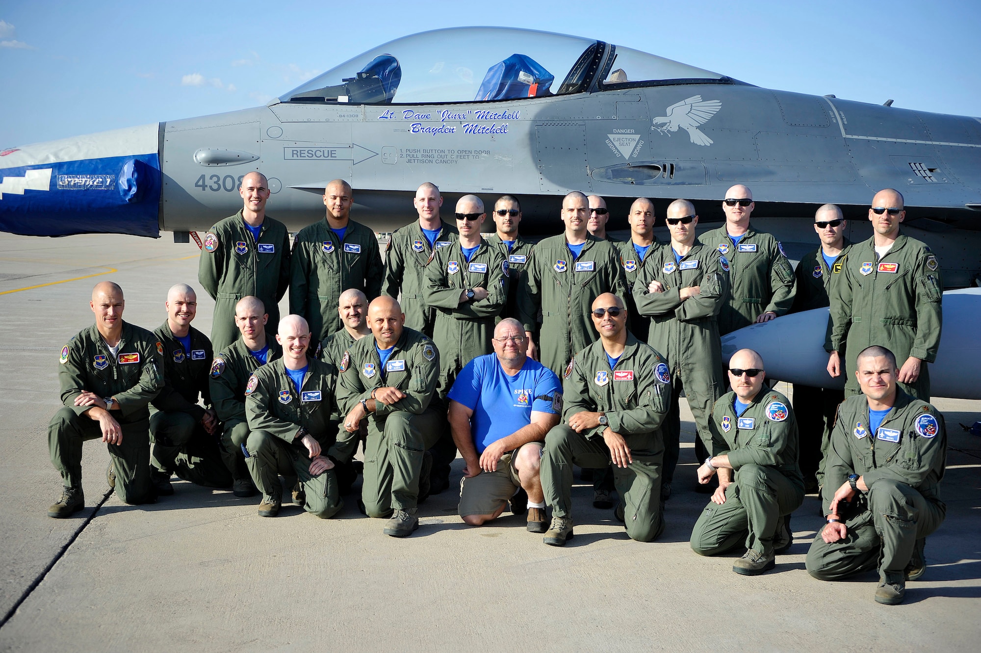 Airmen from the 62nd Fighter Squadron with shaved heads pose March 7 in front of an F-16 Fighting Falcon on the flightline. The Airmen shaved their heads to show support for the son of a deceased 62nd FS pilot who is battling cancer. (U.S. Air Force photo/Senior Airman David Owsianka)