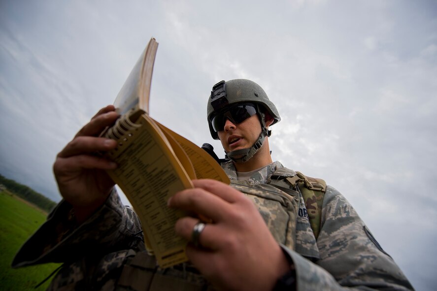 U.S. Air Force Senior Airman Shawn Morgan, 15th Air Support Operations Squadron joint terminal attack controller out of Fort Stewart, Ga., reviews a J-Fire manual during a close air support training mission April 8, 2014, at Moody Air Force Base, Ga. The J-Fire manual is a quick-reference guide for requesting airstrike requests and contains various information including calls for fire and data on weapons. (U.S. Air Force photo by Staff Sgt. Jamal D. Sutter/Released)  