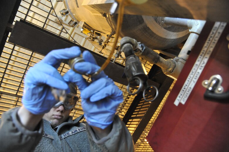 U.S. Air Force Staff Sgt. Preston Sowers, 509th Logistics Readiness Squadron NCO in charge of fuels laboratory, removes a single weight from a sampler at Whiteman Air Force Base, Mo. April 1, 2014. Removing the single weight ensures there is no sediment within the fuel. Sediment within can cause aircraft to malfunction. (U.S. Air Force photo by Airman 1st Class Keenan Berry/Released)  