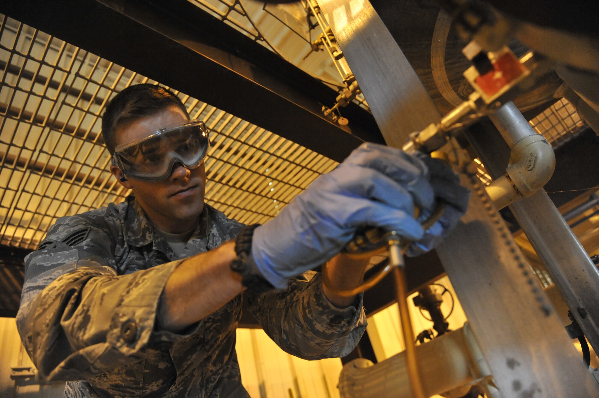 U.S. Air Force Senior Airman Dustin Cournoyer, 509th Logistics Readiness Squadron fuels laboratory technician, removes a single weight from a sampler at Whiteman Air Force Base, Mo. April 1, 2014. This portion of the weekly inspection is done to ensure there is no sediment within the fuel. (U.S. Air Force photo by Airman 1st Class Keenan Berry/Released)  