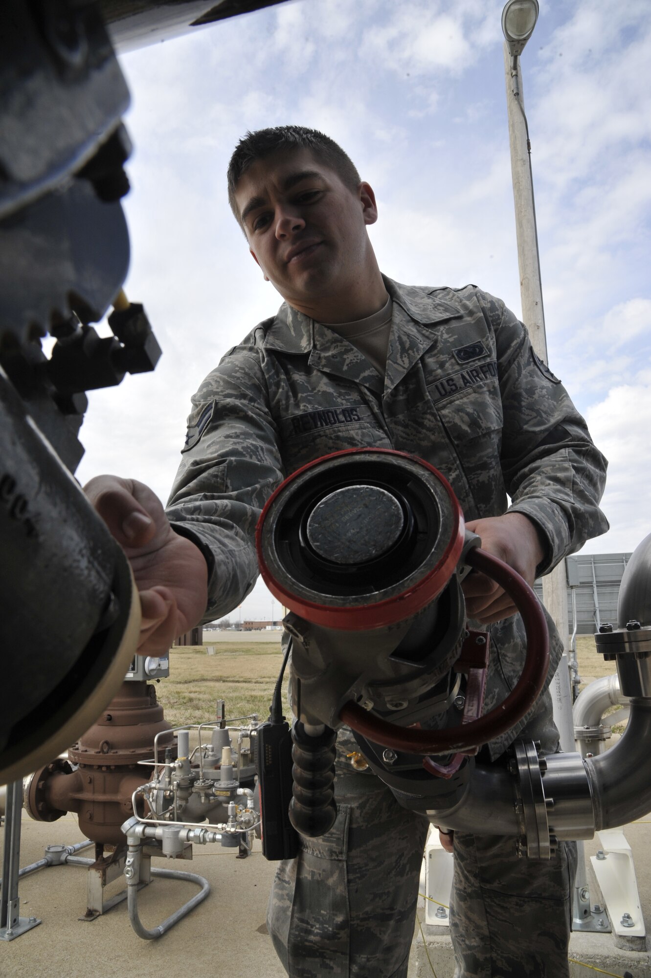 U.S. Air Force Airman 1st Class Joshua Reynolds, 509th Logistics Readiness Squadron fuels distribution technician, disconnects a single point nozzle from an R-11 fuel truck at Whiteman Air Force Base, Mo. April 1, 2014. The single point nozzle attaches to the bottom loader to verify that the metered fill issued prior to filling. (U.S. Air Force photo by Airman 1st Class Keenan Berry/Released)  