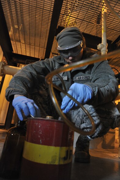 U.S. Air Force Staff Sgt. Preston Sowers, 509th Logistics Readiness Squadron NCO in charge of fuels laboratory, pulls a sample from fuel filter separators at Whiteman Air Force Base, Mo. April 1, 2014. A weekly sample from fuel separators must be taken to ensure it contains no water or sediments. (U.S. Air Force photo by Airman 1st Class Keenan Berry/Released)  