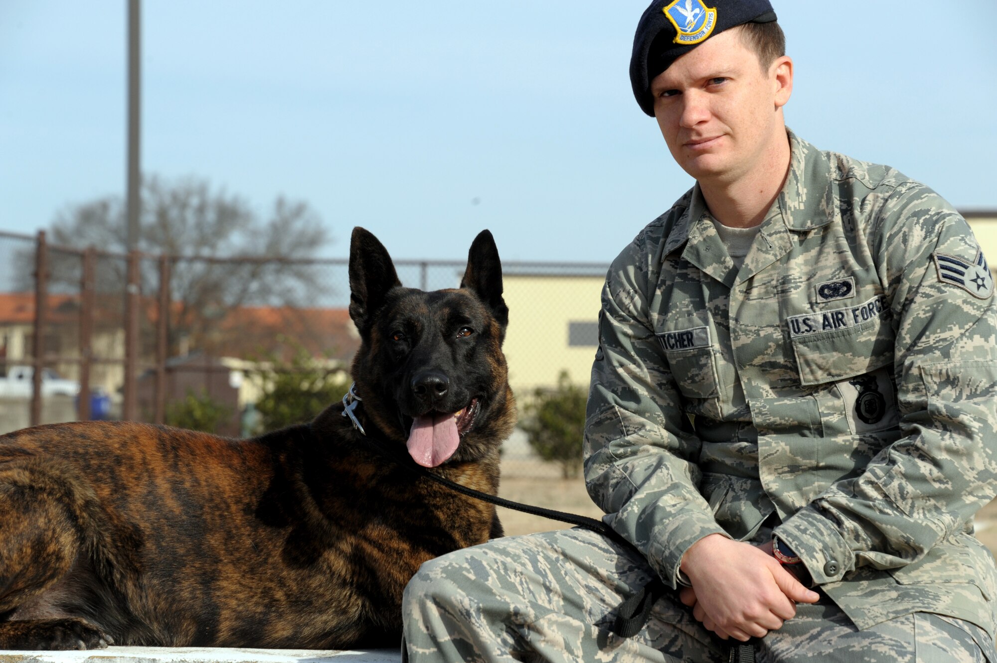 Senior Airman Christopher Stitcher and MWD Sam pose for a photo at Maxwell Air Force Base, 14 Feb.Their mission is to protect base personnel by sniffing out explosives and narcotics, both at the gates and around base. (U.S. Air Force photo by Senior Airman William Blankenship)