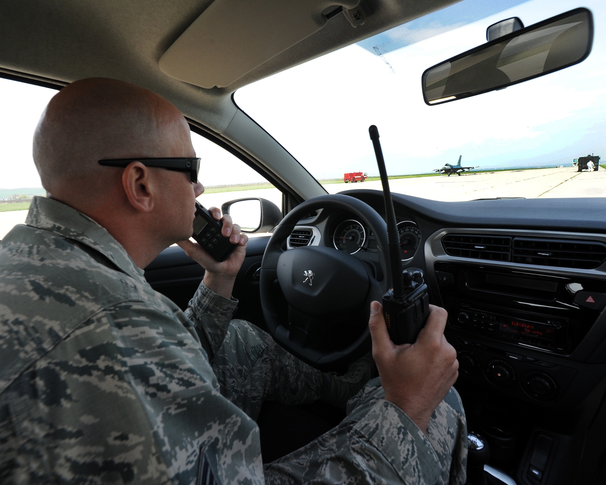 Tech. Sgt. Paul Garcia, a 31st Civil Engineer Squadron firefighter, radios to other firefighters during an arresting cable system test April 9, 2014, at Campia Turzii, Romania. The system is tested before air operations begin. (U.S. Air Force photo/Staff Sgt. R.J. Biermann) 