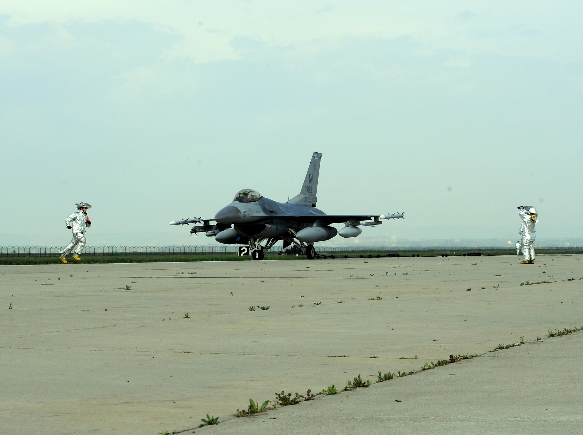 Firefighters assigned to the 31st Civil Engineer Squadron, aid an F-16 Fighting Falcon pilot during an arresting cable system test April 9, 2014, at Campia Turzii, Romania. The system is designed to catch an aircraft’s tail hook in the event its brake system is inoperable. (U.S. Air Force photo/Staff Sgt. R.J. Biermann)