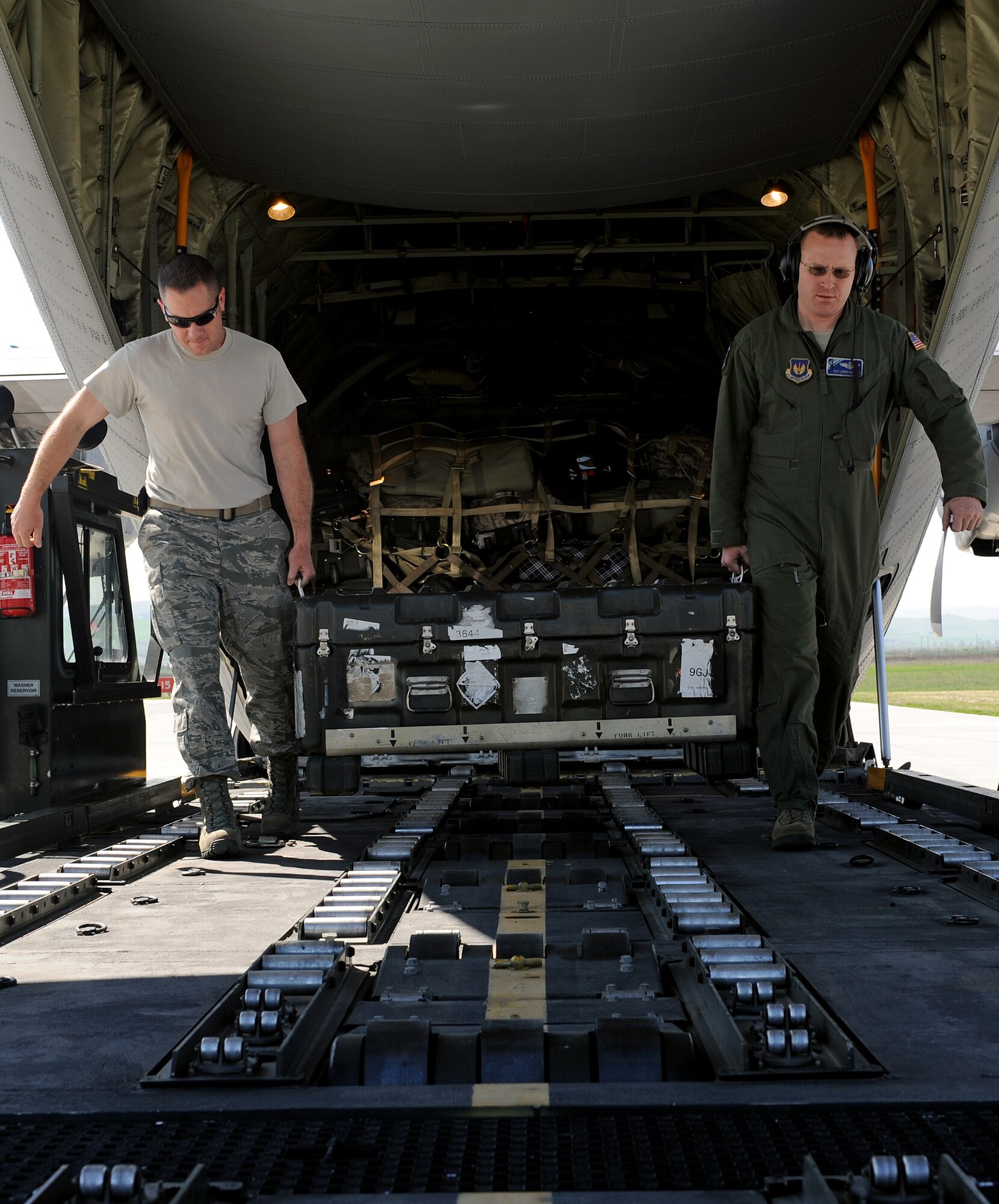 Master Sgt. Francis Watermolen, 31st Logistics Readiness Squadron air operations office section chief, and Tech. Sgt. James Sullivan, 37th Airlift Squadron loadmaster, unload cargo from a C-130J Super Hercules, April 8, 2014, at Campia Turzii, Romania. Airmen from the 31st Fighter Wing arrived at the Romanian air force base to participate in a bilateral training exercise – Dacian Viper 2014. (U.S. Air Force photo/Staff Sgt. R.J. Biermann)