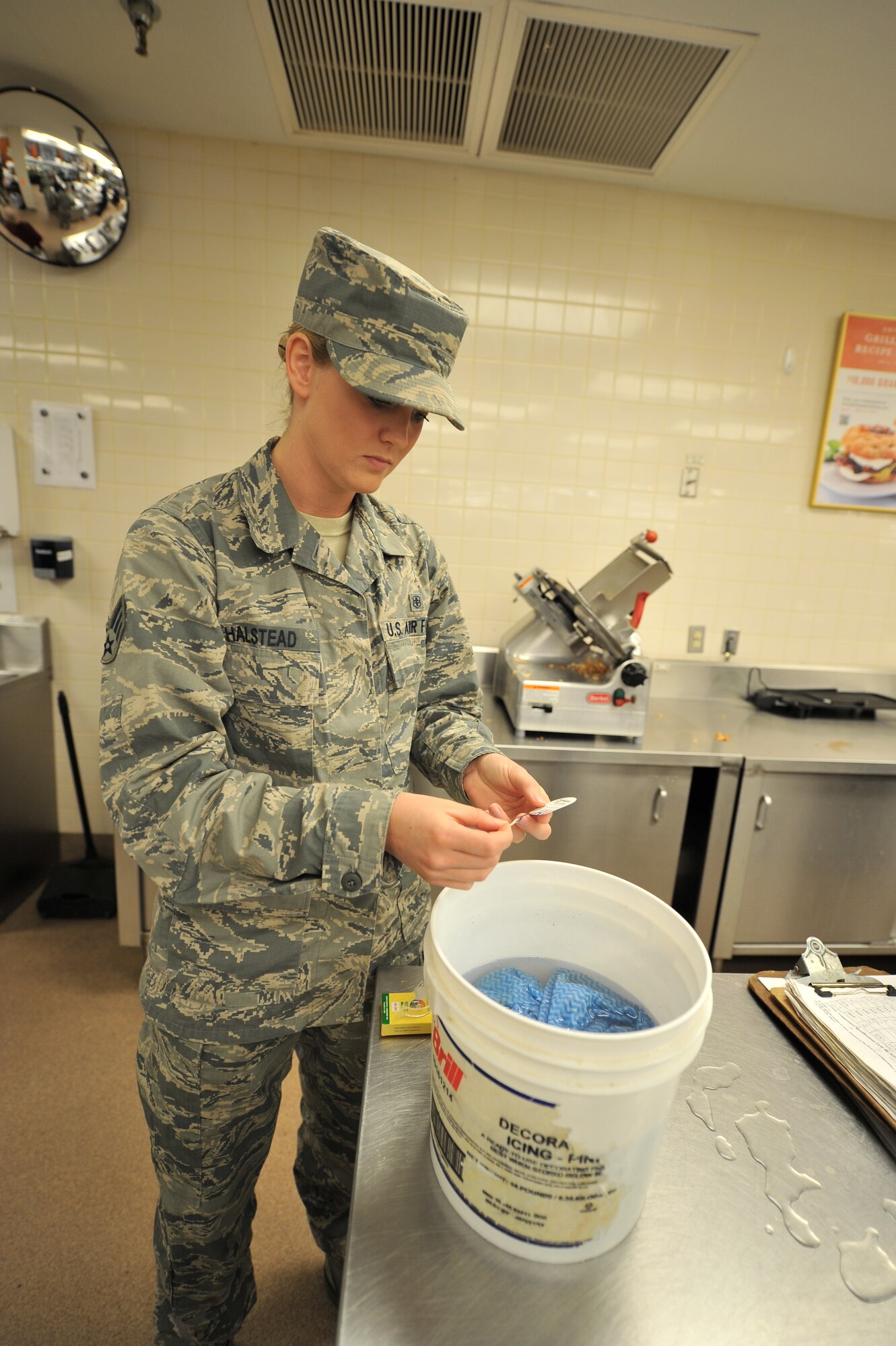 ALTUS AIR FORCE BASE, Okla. – U.S. Air Force Senior Airman Sierra Halstead, 97th Medical Group public health technician, tests the chemical levels of a bucket of sanitizer during a monthly public health inspection inside the base commissary April 9, 2014. The chemical levels of the sanitizer have to be checked to ensure that there is a proper amount of sanitizing chemicals to properly disinfect surfaces. (U.S. Air Force photo by Senior Airman Dillon Davis/Released)