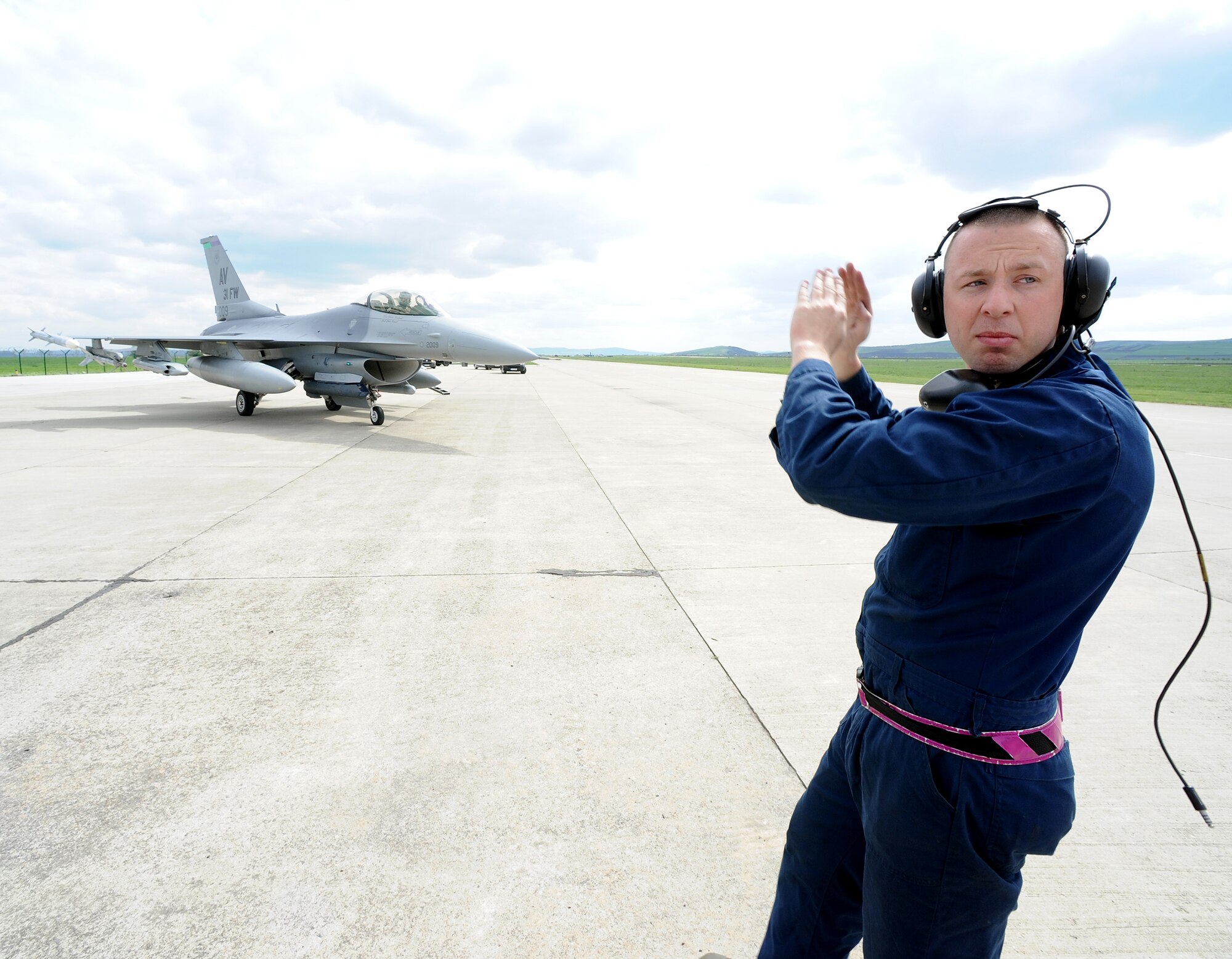 Senior Airman Teric Melhaff, 31st Aircraft Maintenance Squadron crew chief, directs an F-16 Fighting Falcon pilot during Exercise Dacian Viper 2014, at Campia Turzii, Romania, April 10, 2014. The exercise aims to strengthen the cooperative efforts of the U.S. and Romanian air forces.  (U.S. Air Force photo/Staff Sgt. R.J. Biermann)