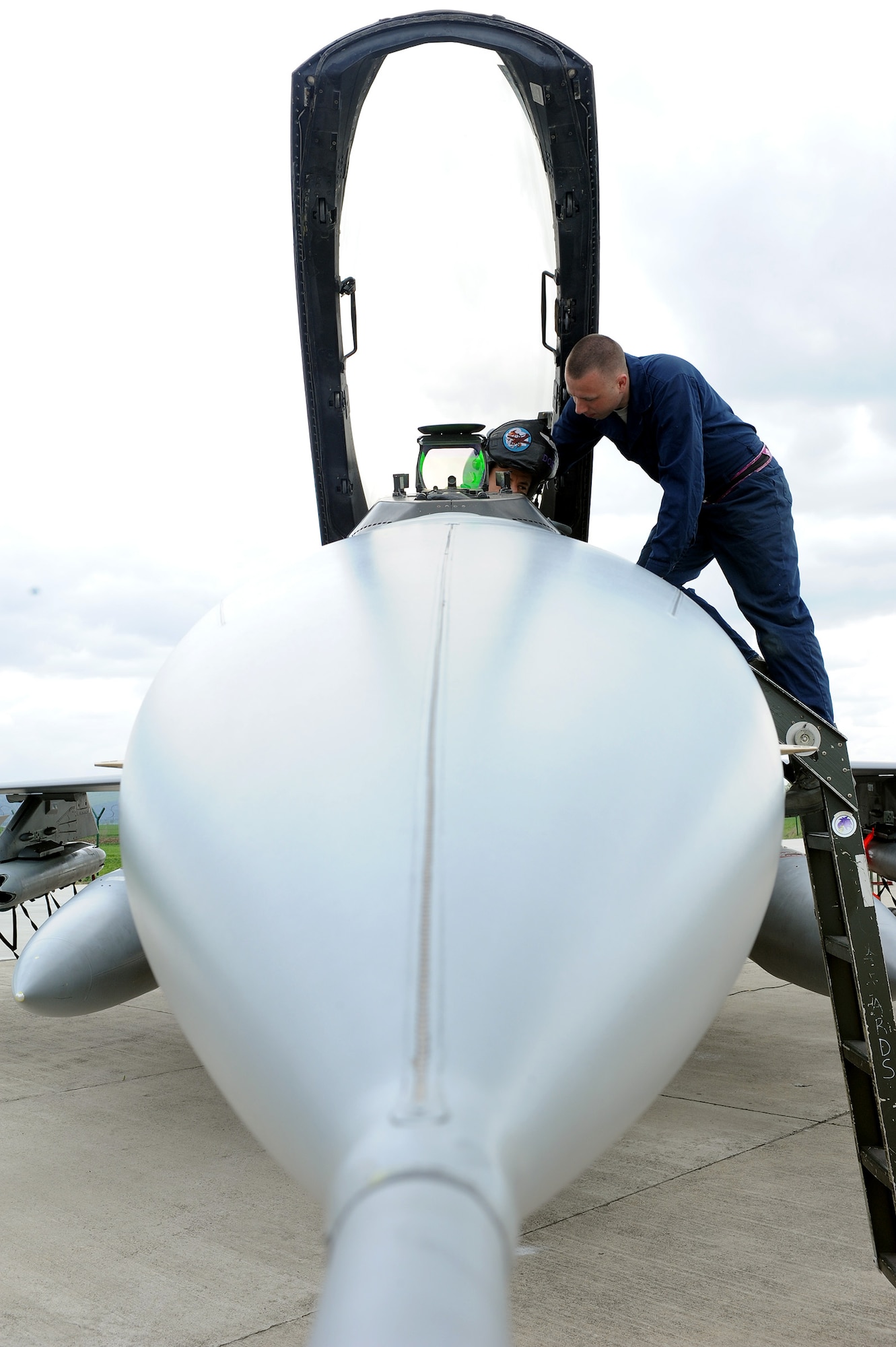 Senior Airman Teric Melhaff, 31st Aircraft Maintenance Squadron crew chief, assists an F-16 Fighting Falcon pilot, with pre-flight checks at Campia Turzii, Romania, April 10, 2014. Aviano Air Base maintainers, crew chiefs, firefighters, aerospace ground equipment technicians, air traffic controllers, and supply, logistics and support personnel arrived at Campia Turzii to participate in Exercise Dacian Viper 2014. (U.S. Air Force photo/Staff Sgt. R.J. Biermann)
