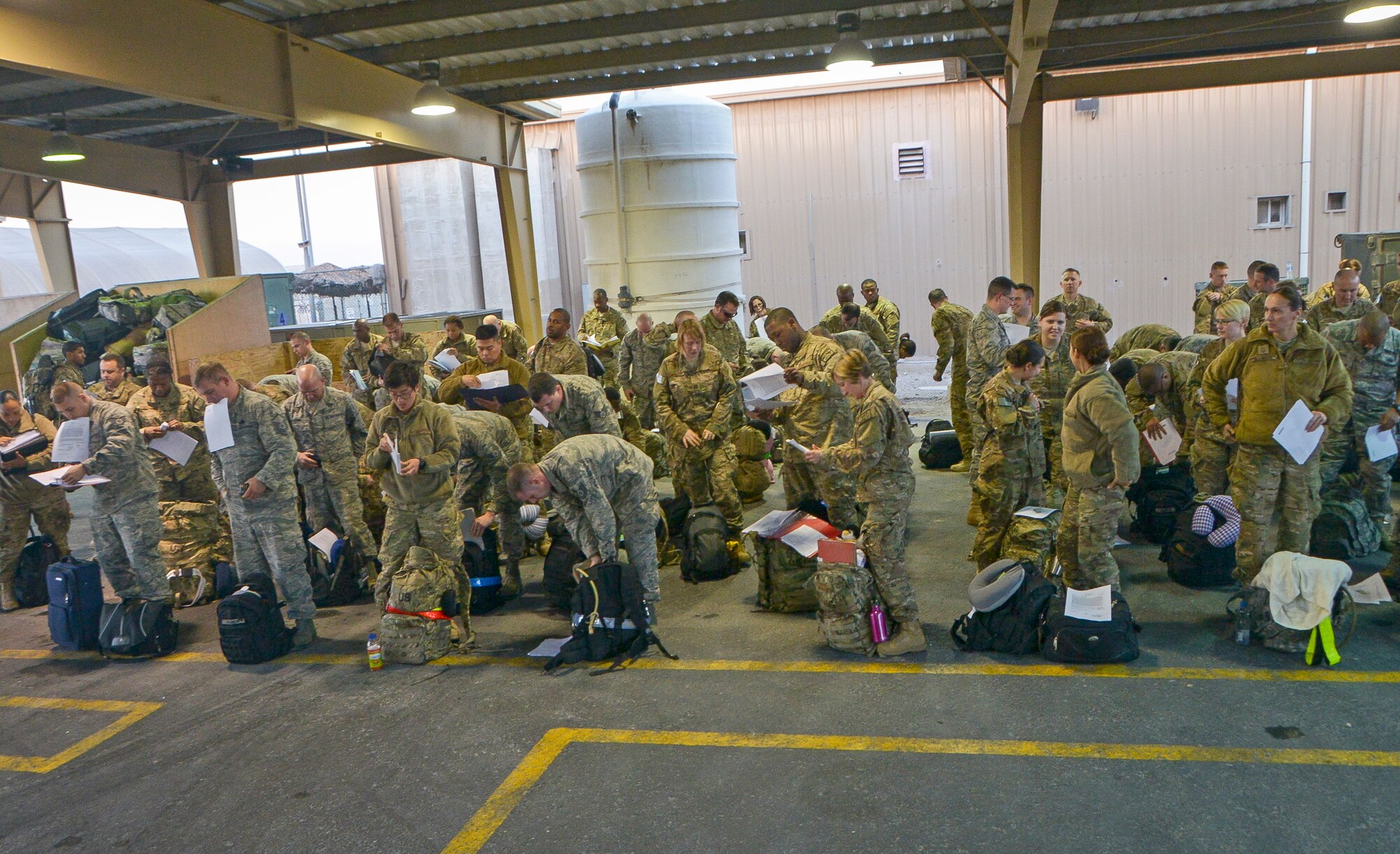 Airmen get their paper work in order after ariving at Al Udeid Air Base, Qatar, April 8, 2014. Every year more than 150,000 military personnel travel through AUAB and the coordination of getting those service members to their final destination is done by the Air Force Transient Reception Control Center. (U.S. Air Force photo/ Senior Airman Jared Trimarchi)