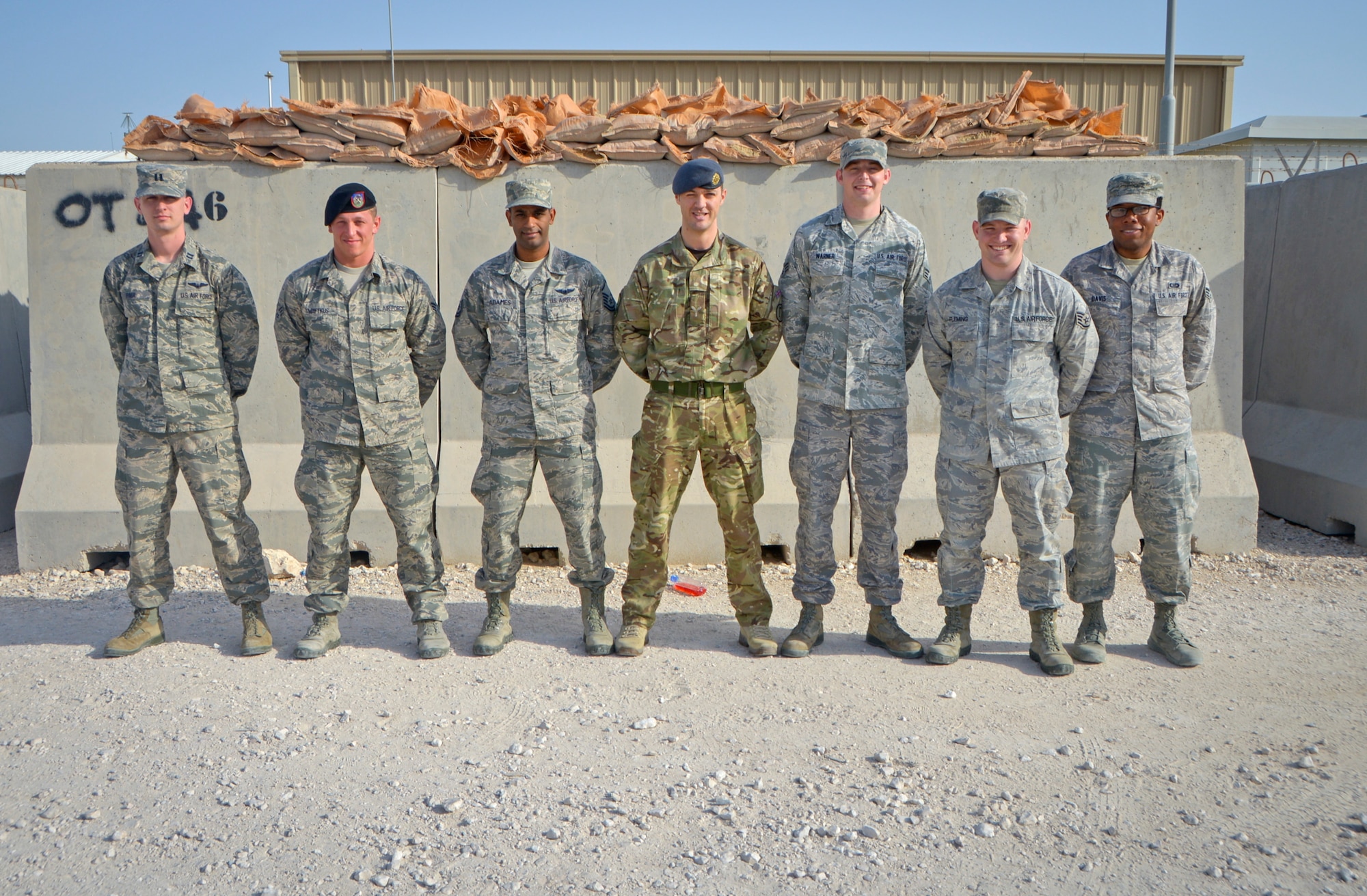 Airmen and a Royal Air Force aircraftsman from the 717th Expeditionary Air Support Operations Squadron pose for a group photo at Al Udeid Air Base, Qatar, April 9, 2014. The 717th EASOS which is part of the 504th Expeditionary Air Support Operations Group, acts as a 911 call center to troops on the ground who are in need of close air support. (U.S. Air Force photo/ Senior Airman Jared Trimarchi)