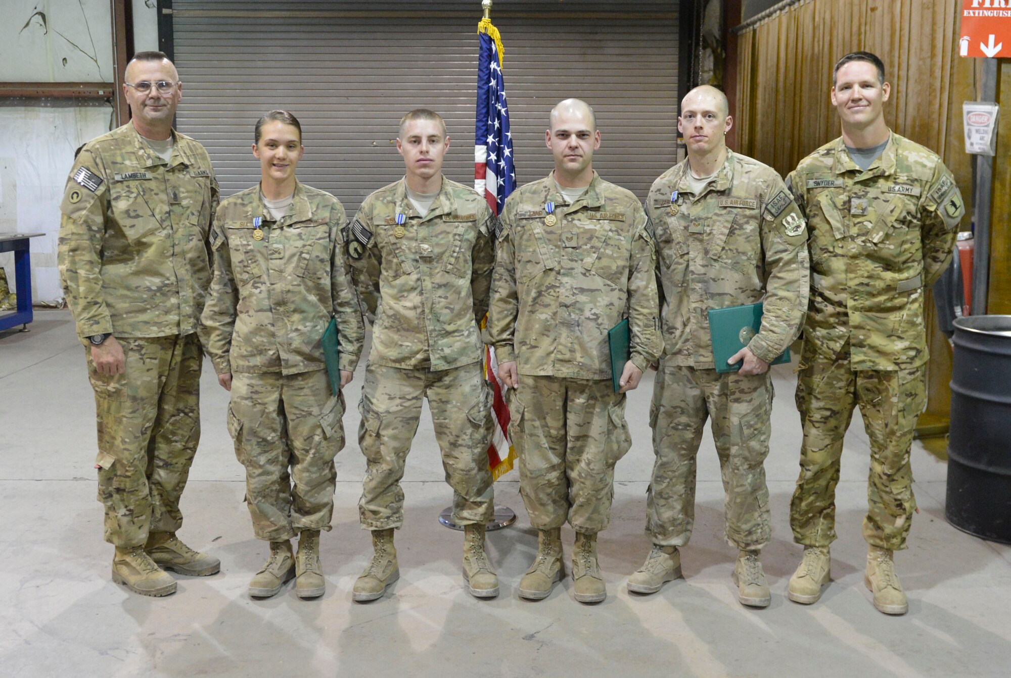 Airmen from the 455th Metal Fabrication shop stand together after being presented the Army Achievement medal at Bagram Airfield, Afghanistan, April 9, 2014. The Airmen were recognized for quickly manufacturing parts needed to get Army helicopters repaired and returned to flying status..(U.S. Air Force photo by Senior Master Sgt. Gary J. Rihn/Released)