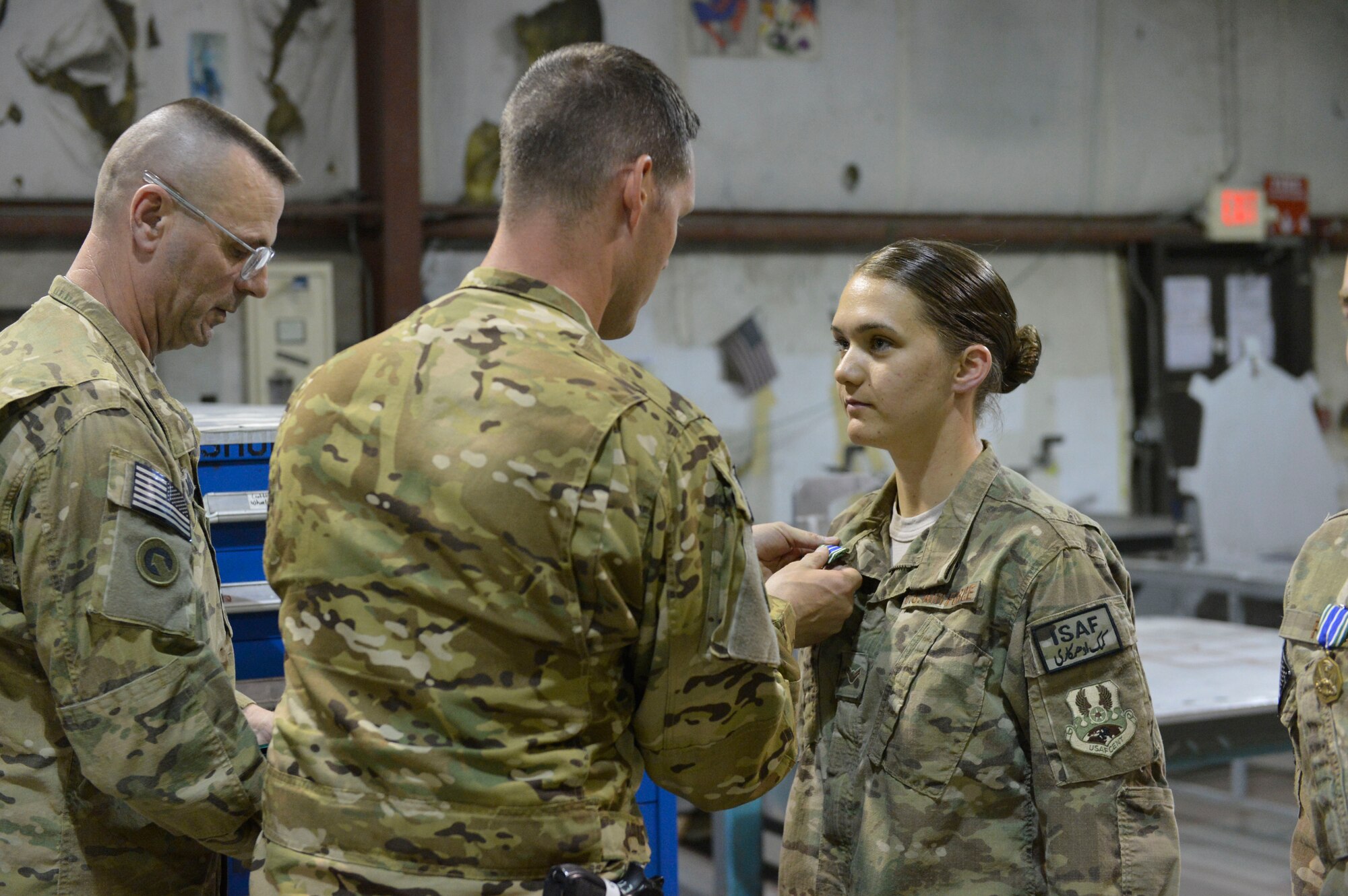 U.S. Air Force Airman 1st Class Ashli Six receives the Army Achievement medal at Bagram Airfield, Afghanistan, April 9, 2014. Six is part of a team of metal fabricators that produced parts that allowed the Army to repair helicopters and get them back in to service quickly.(U.S. Air Force photo by Senior Master Sgt. Gary J. Rihn/Released)