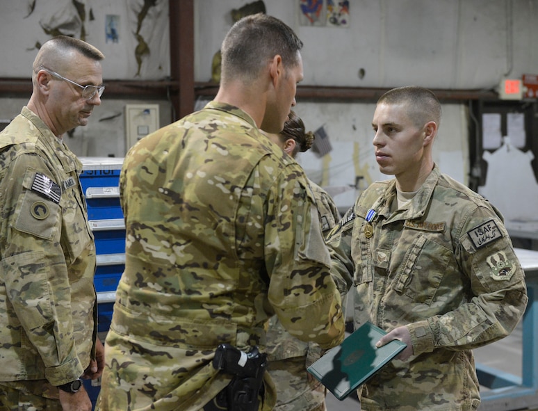 U.S. Air Force Senior Airman Allan Rosso receives the Army Achievement medal at Bagram Airfield, Afghanistan, April 9, 2014. Rosso is part of a team of metal fabricators that produced parts that allowed the Army to repair helicopters and get them back in to service quickly.(U.S. Air Force photo by Senior Master Sgt. Gary J. Rihn/Released)