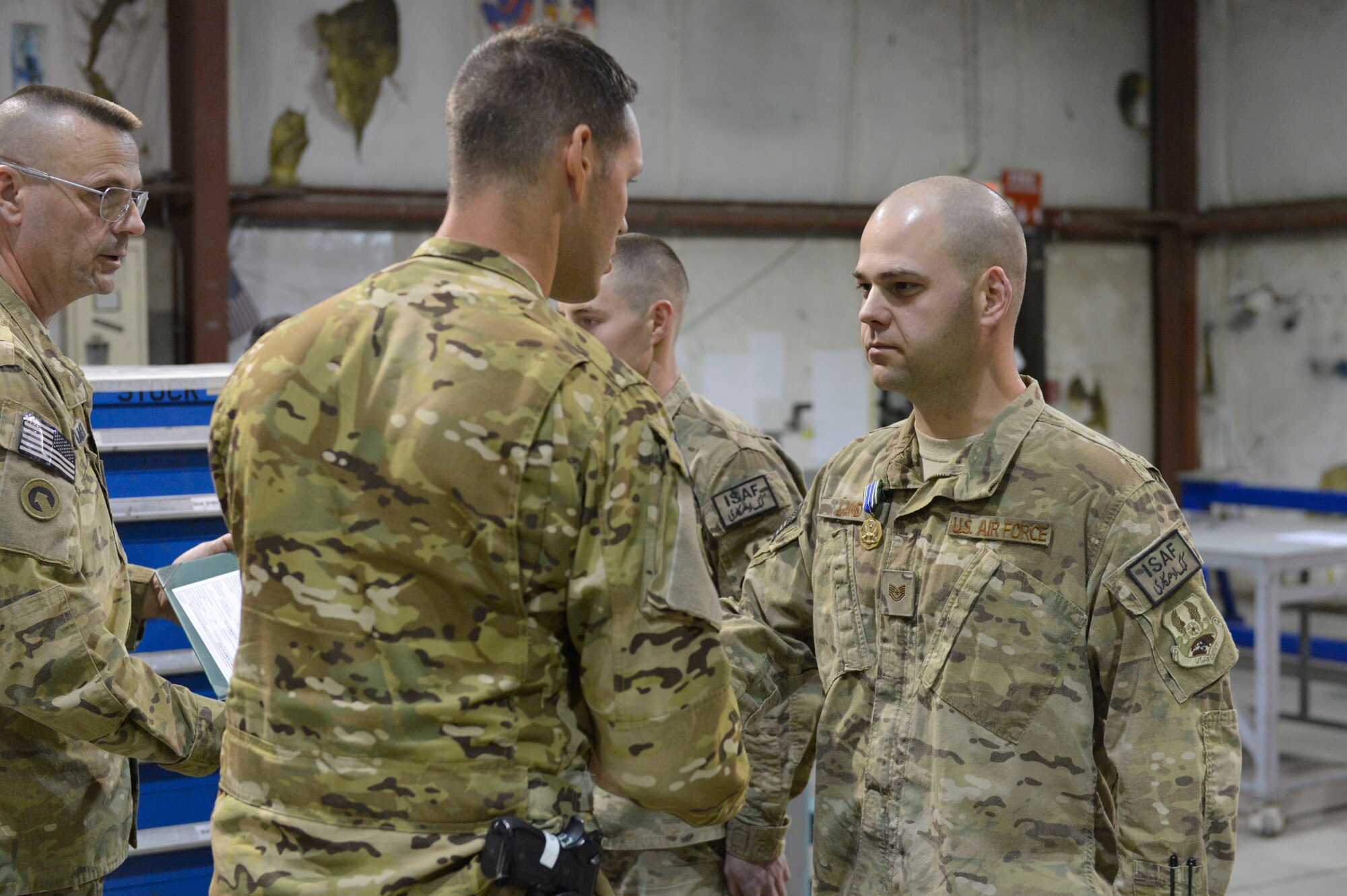 U.S. Air Force Tech. Sgt. David Land receives the Army Achievement medal at Bagram Airfield, Afghanistan, April 9, 2014. Land is part of a team of metal fabricators that produced parts that allowed the Army to repair helicopters and get them back in to service quickly.(U.S. Air Force photo by Senior Master Sgt. Gary J. Rihn/Released)