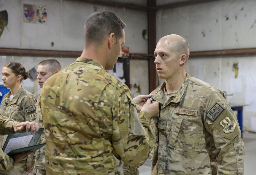 U.S. Air Force Staff Sgt. Ricky Jarvis receives the Army Achievement medal at Bagram Airfield, Afghanistan, April 9, 2014. Jarvis is part of a team of metal fabricators that produced parts that allowed the Army to repair helicopters and get them back in to service quickly.(U.S. Air Force photo by Senior Master Sgt. Gary J. Rihn/Released)